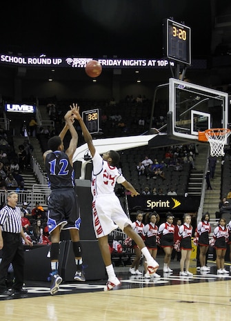 Elijah Childs, 24, a Raytown South High School Cardinal forward, attempts to block a shot by Jailen Gill, 12, a Raytown High School Bluejay center and forward, during the Time Warner Sports Channel Showcase at the Sprint Center here Jan. 20, 2014. Fourteen schools participated in the showcase. Marine recruiters from Recruiting Sub-Stations Overland Park, Independence, Gladstone and Topeka were on hand with a setup display table and pull-up bar.