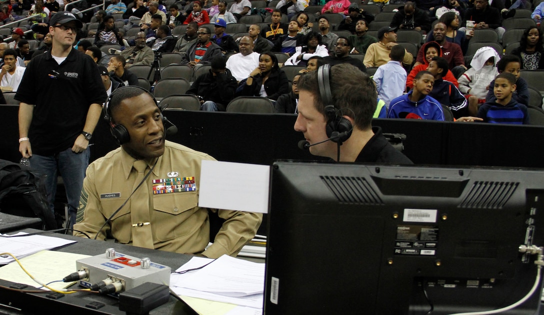 Sgt. Maj. Johnnie Hughes, Recruiting Station Kansas City sergeant major, and Mick Shaffer, a Kansas City Time Warner Cable Sports Channel on-air sports anchor, discuss many of the similarities between being a member of a basketball team and that of the Marine Corps during the Time Warner Cable Sports Channel Showcase at the Sprint Center here Jan. 20, 2014. Several male and female high school basketball teams from the greater Kansas City metropolitan area, such as the Wyandotte High School Bulldogs, Central Academy of Excellence Eagles and Raytown South High School Cardinals, competed in the showcase. 