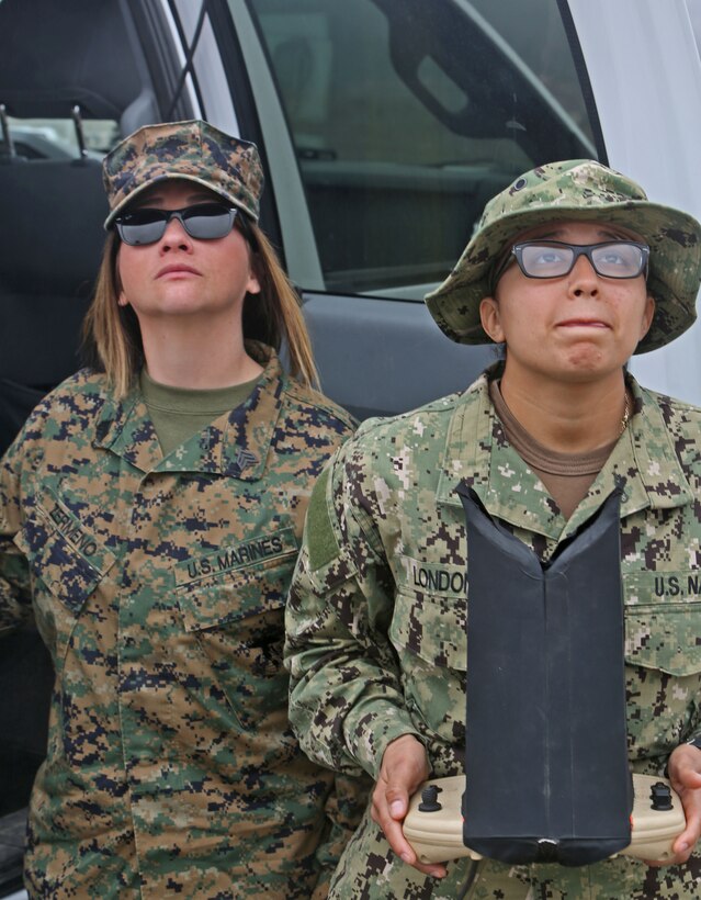 Sergeant Cynthia Zermeno, (left) a training noncommissioned officer with 1st Medical Battalion, Combat Logistics Regiment 15,1st Marine Logistics Group, and Navy Petty Officer 3rd Class Nathalia Londono, (right) a master at arms with Marine Corps Security Forces Battalion, land an unmanned aerial vehicle during a UAV course aboard Camp Pendleton, Calif., Jan. 30, 2014. The UAV course is two weeks long and focuses on familiarizing Marines and sailors with the equipment needed to control a UAV primarily through practical application.