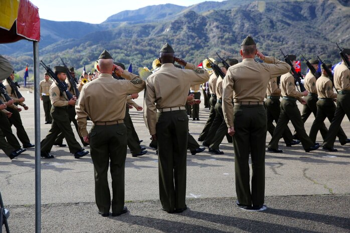 Sergeant Maj. James Cully, left, outgoing sergeant major, 1st Marine Regiment, Sgt. Maj. Reginald Robinson, middle, incoming sergeant major, and Col. Peter Baumgarten, commanding officer, 1st Marines, salute as the regiment conducts a pass and review during a relief and appointment ceremony aboard Camp Pendleton, Calif., Feb. 7, 2014. Relief and appointment ceremonies are one of the many traditions upheld in the Marine Corps today, which involves the passing of the noncommissioned officer sword from the outgoing sergeant major to the incoming. The passing of the sword signifies the transfer of responsibilities and accountability from one senior enlisted Marine to another.