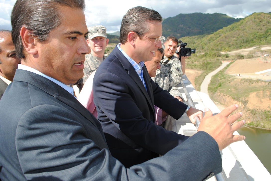 Pablo Vazquez-Ruiz, resident engineer overseeing construction at Portugues Dam, shows the dam's spillway to Puerto Rico Governor Alejandro Garcia Padilla following a dedication ceremony celebrating completion of construction Feb. 5. The $386 million dam is the first roller-compacted concrete dam built by the U.S. Army Corps of Engineers. 