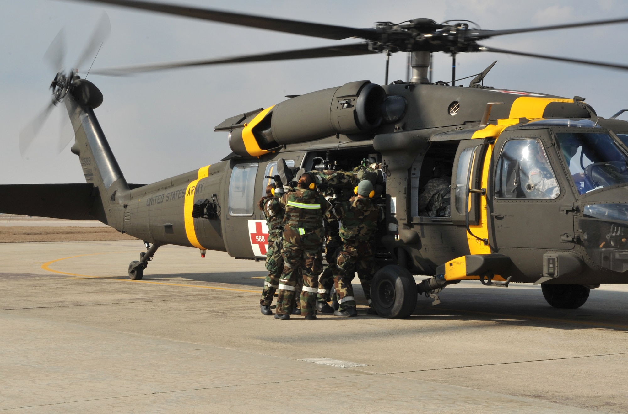 Members of the 51st Medical Group help Soldiers from the 3rd General Support Aviation Battalion at U.S. Army Garrison Humphreys, Republic of Korea, unload a mock casualty from a Black Hawk medevac helicopter during a medevac and dust-off scenario as part of Operational Readiness Exercise Beverly Midnight 14-02 at Osan Air Base, ROK, Feb. 12, 2014. OREs are a unique opportunity for medical personnel to participate in joint training with other branches of the military, mimicking operations in a real-world engagement. (U.S. Air Force photo/Airman 1st Class Ashley J. Thum)