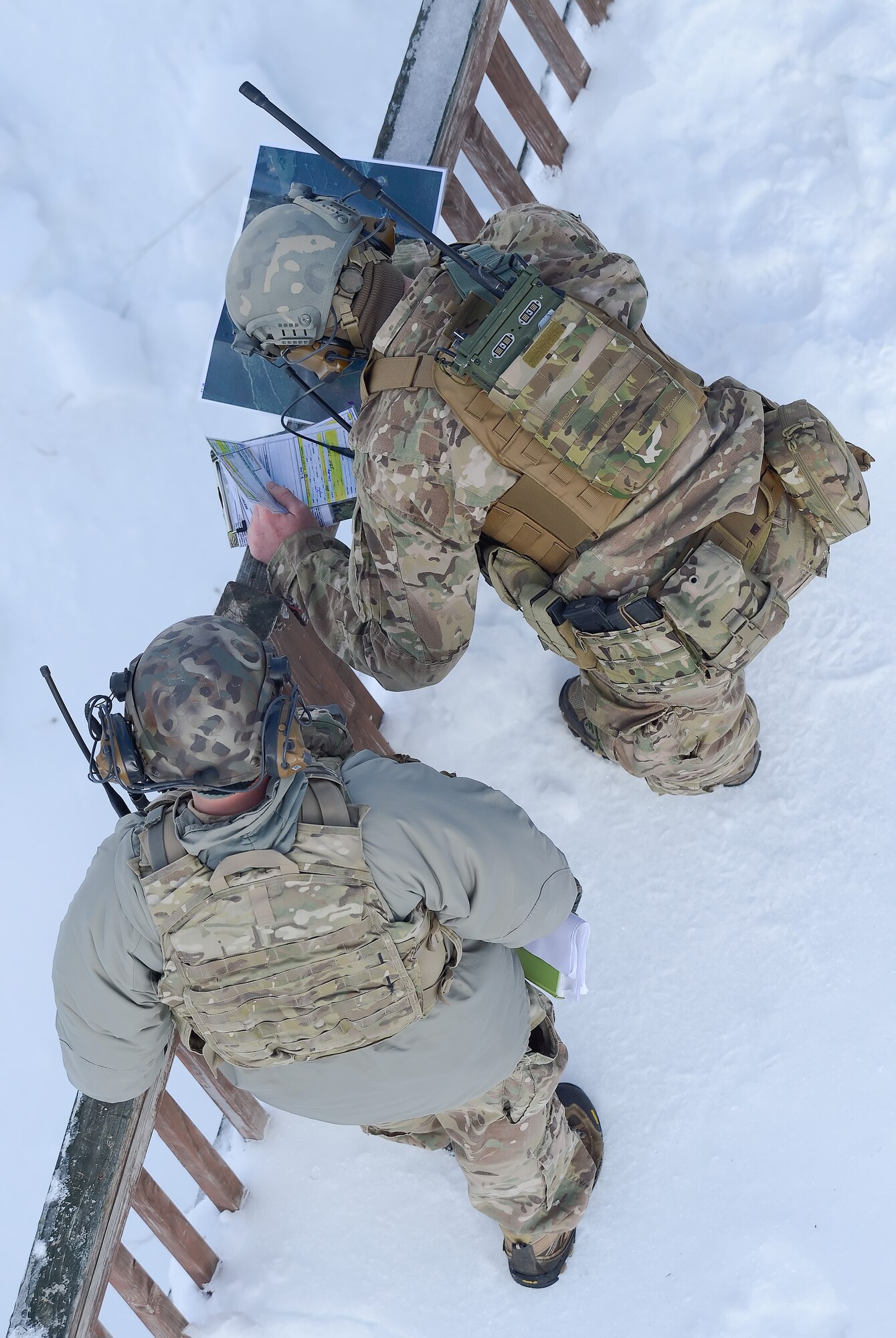 Two joint terminal air controllers from the 11th Air Support Operations Squadron, 3rd Air Support Group, which supports the U.S. Army's 3rd Armored Calvary Regiment, Fort Hood, Texas, work together to plot targets from an observation point near a range tower during a joint-training exercise at the Bollen Live-Fire Range Complex on Feb. 6, 2014, at Fort Indiantown Gap, Pa. The JTAC controllers are working with C-17A Globemaster III and A-10C Thunderbolt II aircraft in the mountainous, snowy terrain of central Pennsylvania. Bollen Range is operated by the 193rd Special Operations Wing, Detachment 1, and supports live-fire training activities for most fighter units as well as helicopter, heavy transport and special mission aircraft in the northeastern United States. (U.S. Air Force photo/Greg L. Davis)
