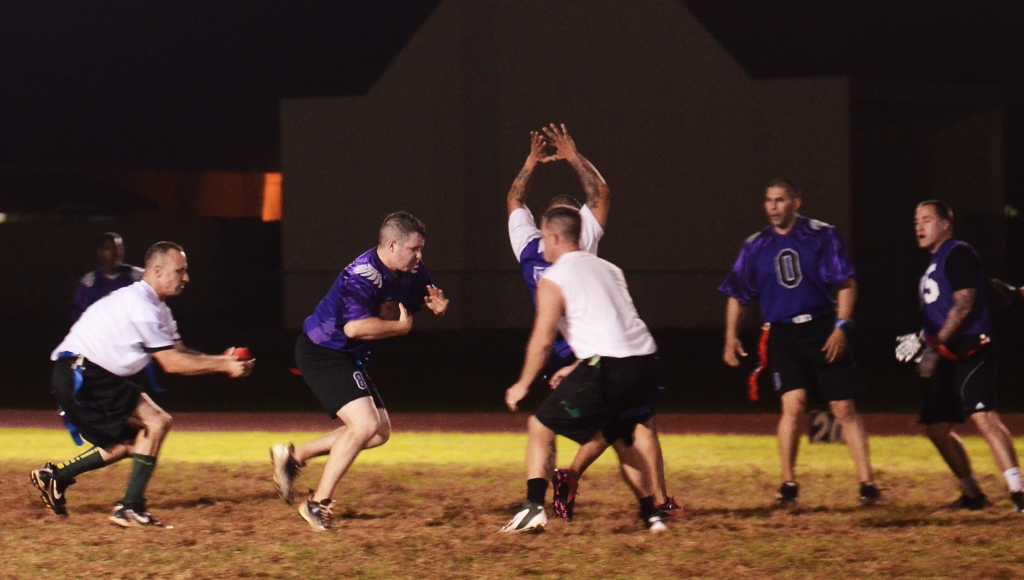 Ernest Clemons, 36th Security Forces Squadron, attempts to evade his opponents during an intramural flag football playoff game between 36th SFS and 736th Security Forces Squadron on Andersen Air Force Base, Guam, Jan. 14, 2014. The championship game is scheduled for Jan. 17 at 6 p.m. (U.S. Air Force photo by Airman 1st Class Mariah Haddenham/Released)