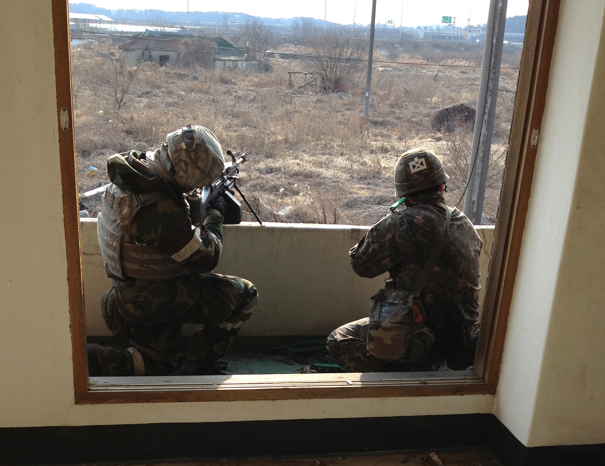 A defender from the 51st Security Forces Squadron and a member of the Republic of Korea army 4th Battalion provide cover from high ground during a joint mission as part of Operational Readiness Exercise Beverly Midnight 14-02 in a training area outside Osan Air Base, ROK, Feb. 12, 2014. Joint training exercises allow the 51st SFS to share their tactical skills and knowledge of the region surrounding the base with their ROKA counterparts. (U.S. Air Force courtesy photo/1st Lt. Tate Grogan) 