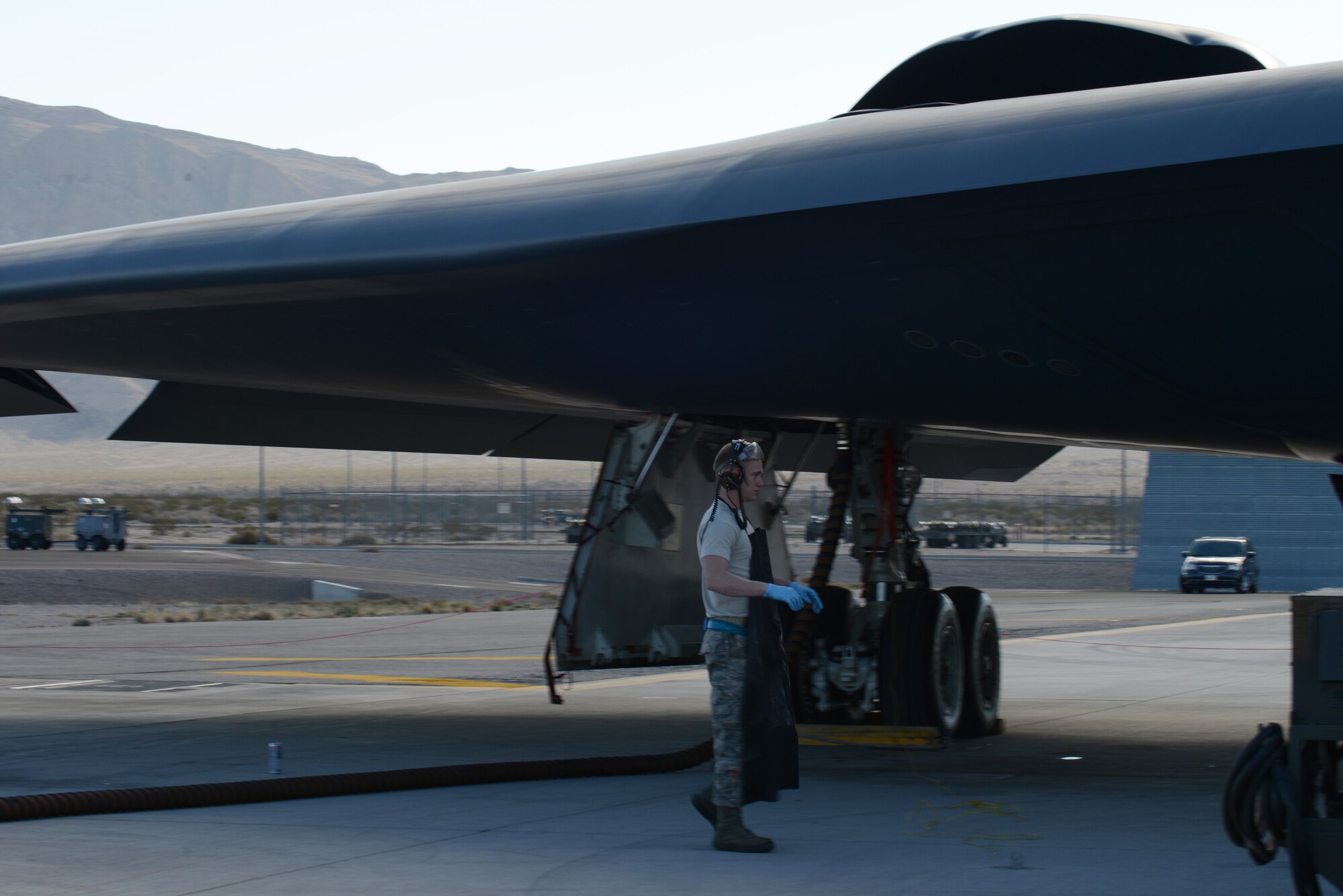 Airman 1st Class Matthew Helms, 509th Aircraft Maintenance Squadron crew chief from Whiteman Air Force Base, Mo., walks beneath a B-2 Spirit after completing routine maintenance Feb. 10, 2014, at Nellis AFB, Nev. Helms is at Nellis AFB, participating in the combat exercise Red Flag 14-1. Red Flag missions present many challenges to test the aircrew’s ability to execute its mission anytime in an operationally contested and degraded environment. (U.S. Air Force photo by Senior Airman Benjamin Sutton/Released) 