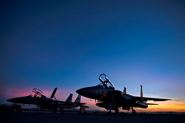 Two F-15E Strike Eagles assigned to the 391st Fighter Squadron, Mountain Home Air Force Base, Idaho, park on the Nellis AFB, Nev., flightline as the sun sets Feb.10, 2014. More than 3,200 service members and 125 aircraft from joint U.S. and allied combat forces from around the world are currently participating in Red Flag 14-1, hosted by the 414th Combat Training Squadron. The main objective of the exercise is to increase the capabilities of combat force for future threats.  (U.S. Air Force photo by Lorenz Crespo)