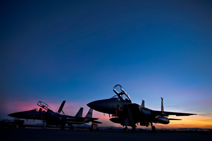 Two F-15E Strike Eagles assigned to the 391st Fighter Squadron, Mountain Home Air Force Base, Idaho, park on the Nellis AFB, Nev., flightline as the sun sets Feb.10, 2014. More than 3,200 service members and 125 aircraft from joint U.S. and allied combat forces from around the world are currently participating in Red Flag 14-1, hosted by the 414th Combat Training Squadron. The main objective of the exercise is to increase the capabilities of combat force for future threats.  (U.S. Air Force photo by Lorenz Crespo)