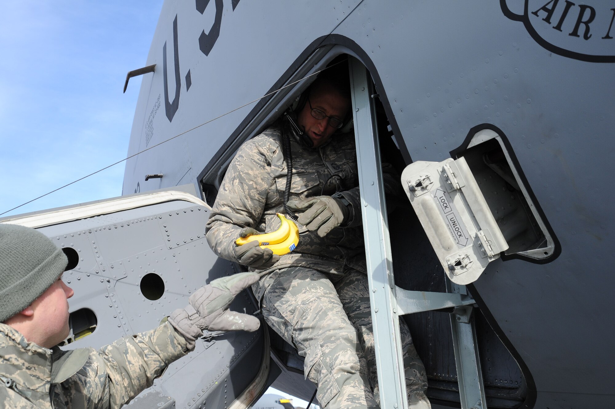 Senior Master Sgt. Lester Gaither, 92nd Aircraft Maintenance Squadron aircraft maintenance unit assistant superintendent, hands out bananas to 92nd AMXS Airmen working inside a KC-135 Stratotanker at Fairchild Air Force Base, Wash., Feb. 6, 2013. Personnel from the base chapel handed out snacks and hot chocolate to keep Airmen warm while working on the flightline during wind chills up to -20 degrees. (U.S. Air Force photo by Airman 1st Class Janelle Patiño/Released)