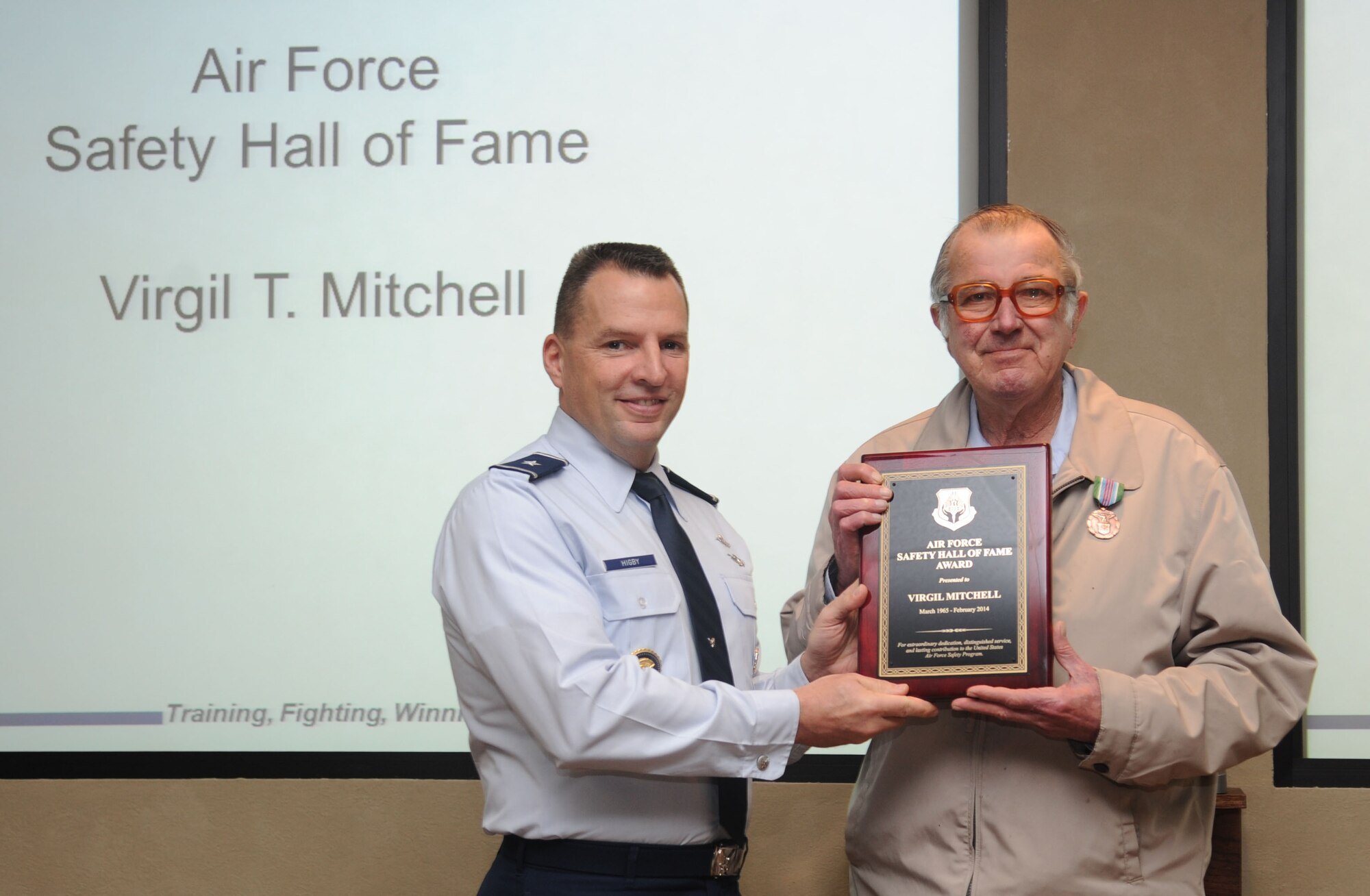 Brig. Gen. Patrick Higby, 81st Training Wing commander presents Virgil Mitchell, 81st Training Wing safety office, with an Air Force Safety Hall of Fame plaque during the 81st TRW staff meeting Feb. 12, 2014, Keesler Air Force Base, Miss.  Mitchell also received the Exemplary Civilian Service Award.  (U.S. Air Force photo by Kemberly Groue)