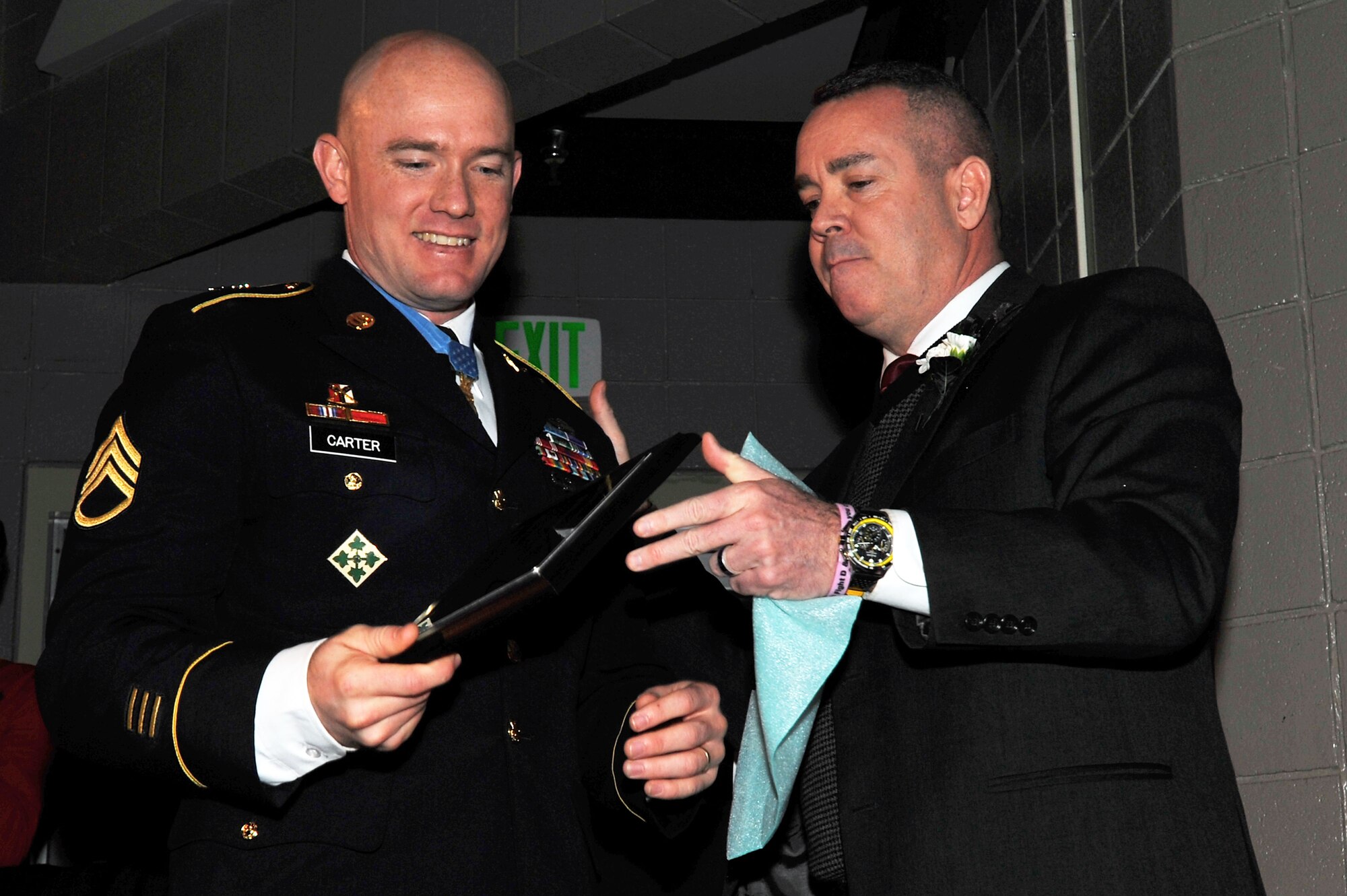 Steve Fisk, North Central High School president, congratulates U.S. Army Staff Sgt. Ty Carter, while he was recognized as this year’s distinguished alumnus Feb. 7, 2014, during the annual Red and Black Convocation at North Central High School in Spokane, Wash. Carter, a graduate of the high school from the class of 1998, received the Medal of Honor from President Barack Obama at the White House in August 2013, for his valor and actions on the battle field in Afghanistan. (U.S. Air Force photo by Staff Sgt. Veronica Montes/Released)