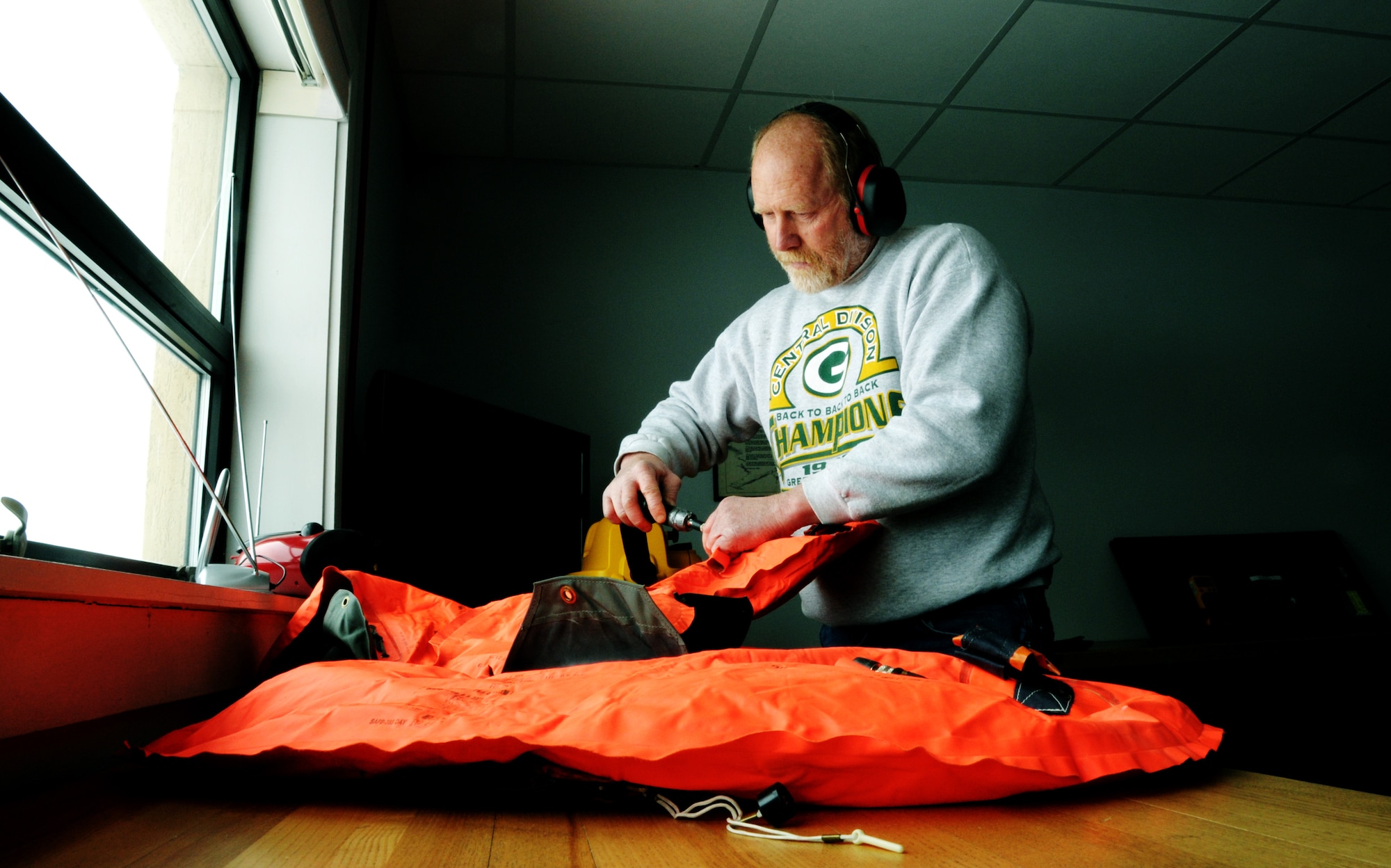 James Knake tests the air pressure and repacks a C-21 floatation devices in the parachute and fabrication shop on Scott Air Force Base, Ill, Feb. 5, 2014. Knake daily duties entail repairing and repacking C-21 floatation equipment and anit-exposure suits.  Knake is a survival and fabrication technician and a native of Harvard, Ill.  (U.S. Air Force photo/ Staff Sgt. Stephenie Wade)