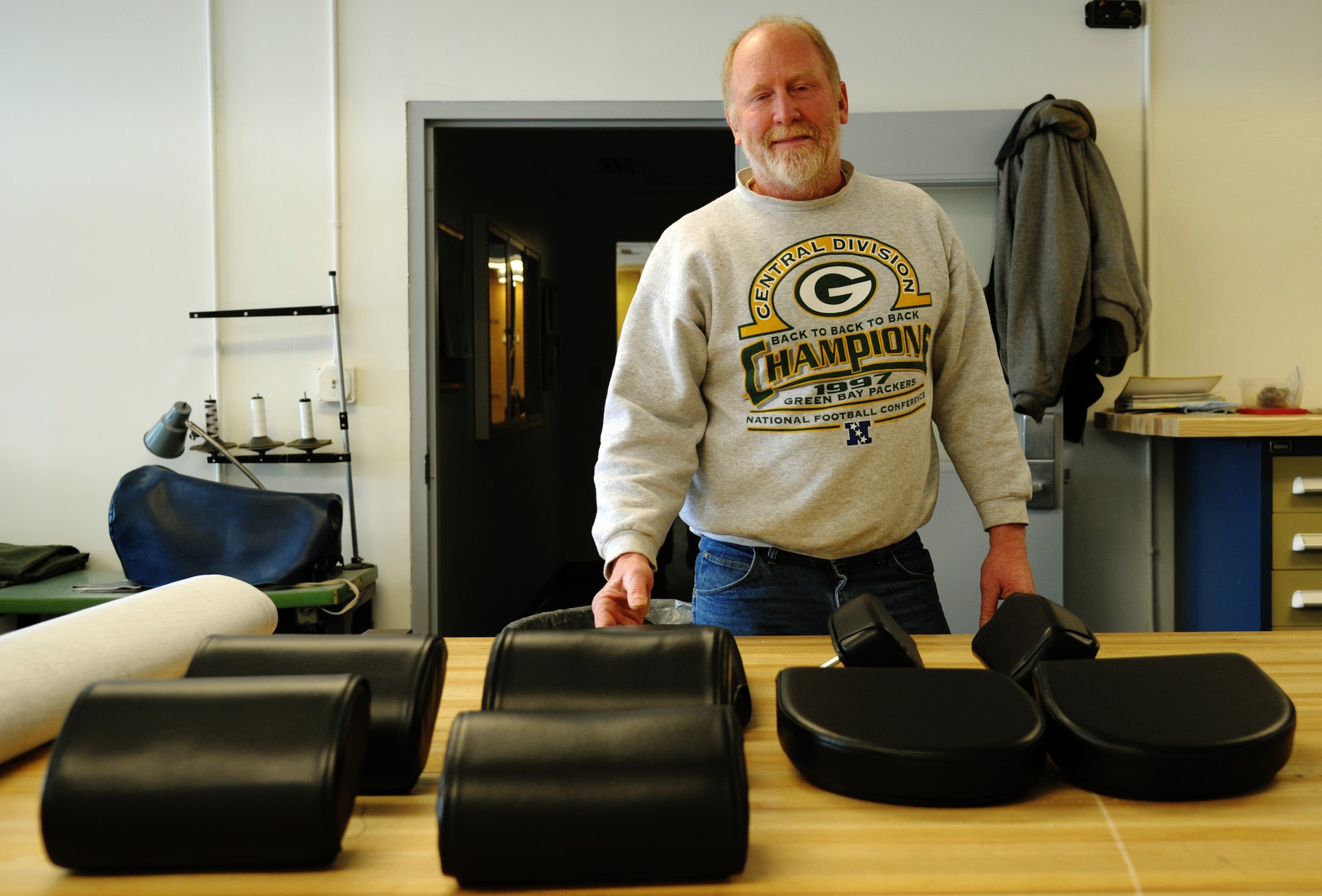 James Knake stands in front of completed weight bench seats in the parachute and fabrication shop on Scott Air Force Base, Ill, Feb. 5, 2014. Knake makes new covers for the base gym equipment all year round saving the Air Force 5,000 annually on top of his daily duties of repairing and repacking C-21 floatation equipment and anit-exposure suits.  Knake is a survival and fabrication technician and a native of Harvard, Ill.  (U.S. Air Force photo/ Staff Sgt. Stephenie Wade)