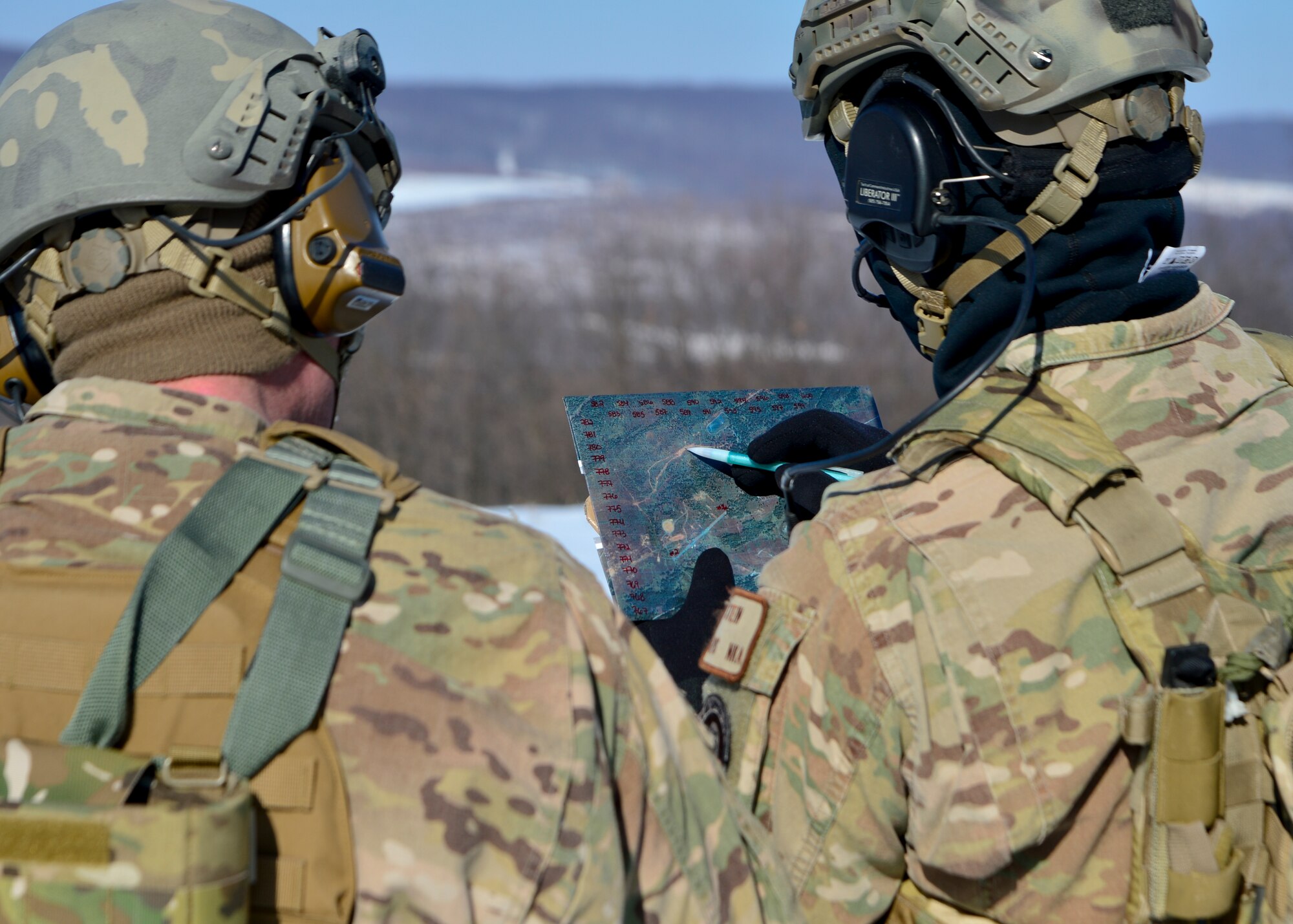 Two joint terminal air controllers from the 11th Air Support Squadron at Fort Hood, Texas, plot coordinates for targeting acquisition for an A-10C Thunderbolt II during a live-fire training exercise Feb. 6, 2014, at the Bollen Live-Fire Range Complex on Fort Indiantown Gap, Pa. The JTACS coordinated with an A-10C Thunderbolt II to strike multiple armored personnel carriers with 30 millimeter training rounds on Bollen Range. (U.S. Air Force photo/Airman 1st Class William Johnson)