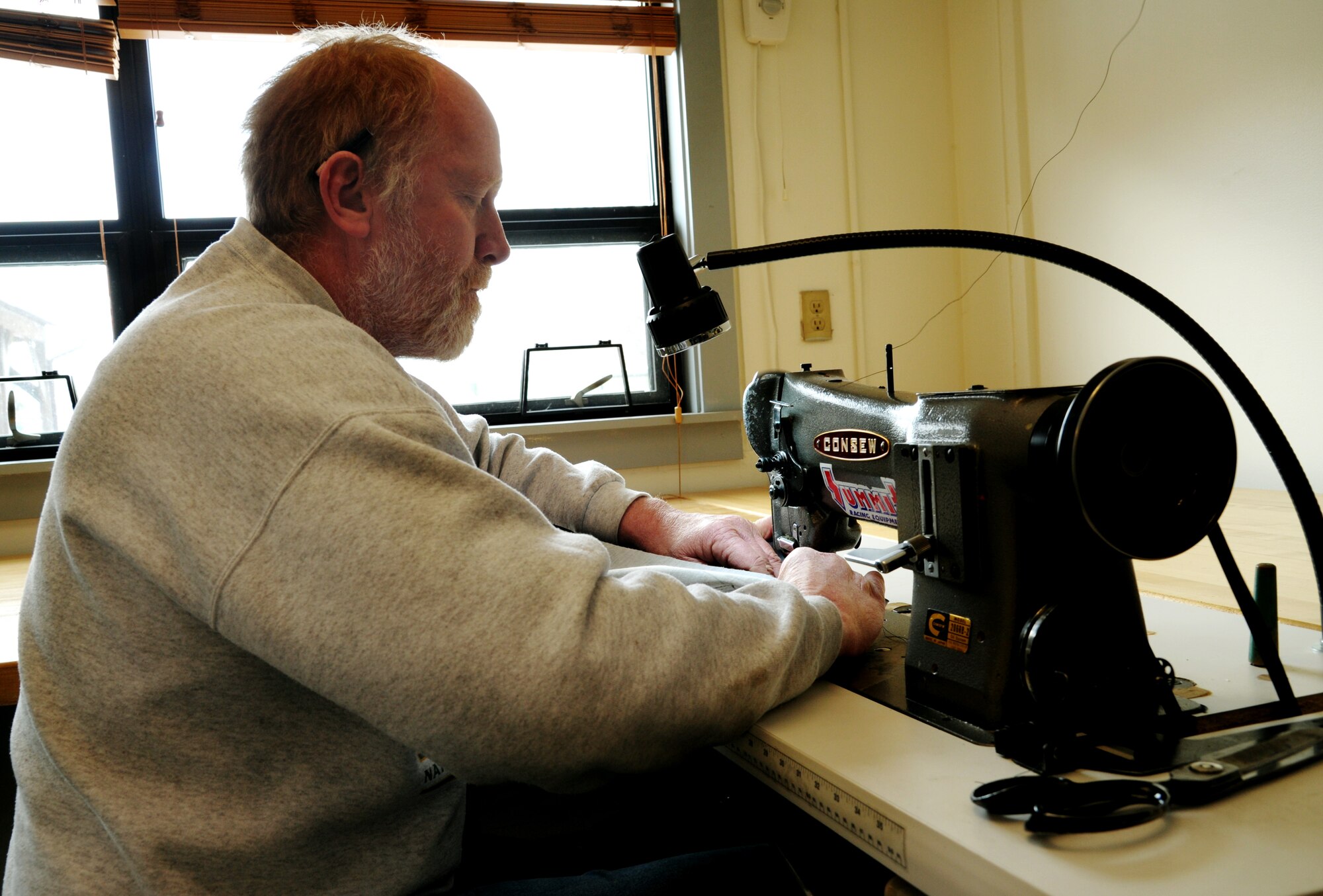 James Knake, sews material together to make a seat cover in the parachute and fabrication shiop on Scott Air Force Base, Ill, Feb. 5, 2014. Knake is a survival and fabrication technician and a native of Harvard, Ill.  (U.S. Air Force photo/ Staff Sgt. Stephenie Wade)