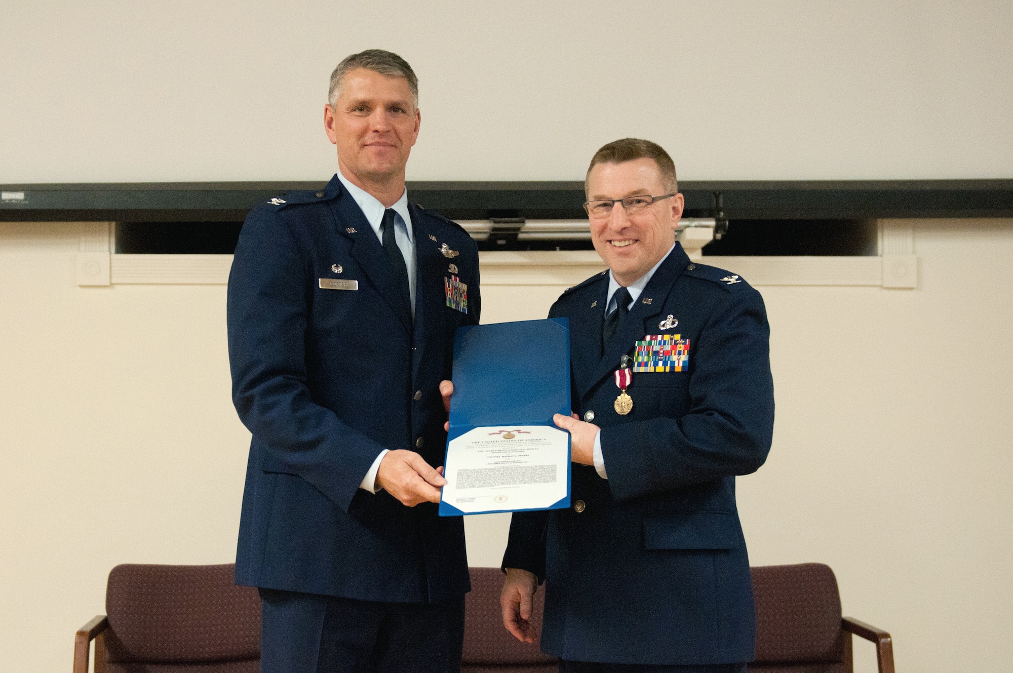 Col. Jeffrey Peters, the outgoing commander of the 123rd Mission Support Group, receives a Meritorious Service Medal from Col. Barry Gorter, commander of the 123rd Airlift Wing, during Peters’ retirement ceremony at the Kentucky Air National Guard Base in Louisville, Ky., Jan. 11, 2014. Peters served in the U.S. Air Force and Air National Guard for 28 years. (U.S. Air National Guard photo by Airman 1st Class Joshua Horton)
