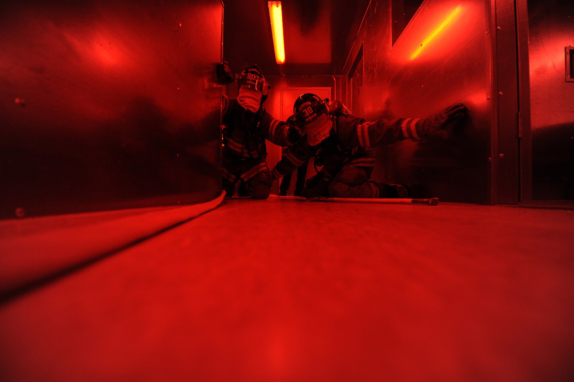 GOODFELLOW AIR FORCE BASE, Texas – Jade Hughes and Chris Little, San Angelo Fire Department recruits, feel their way down a hall in the search and rescue trainer at the Louis F. Garland DoD Fire Academy here Feb. 6. The blindfolded SAFD recruits searched with one hand and used their other hand to keep constant contact with their partner, so they wouldn’t lose each other. (U.S. Air Force photo/ Staff Sgt. Austin Knox)