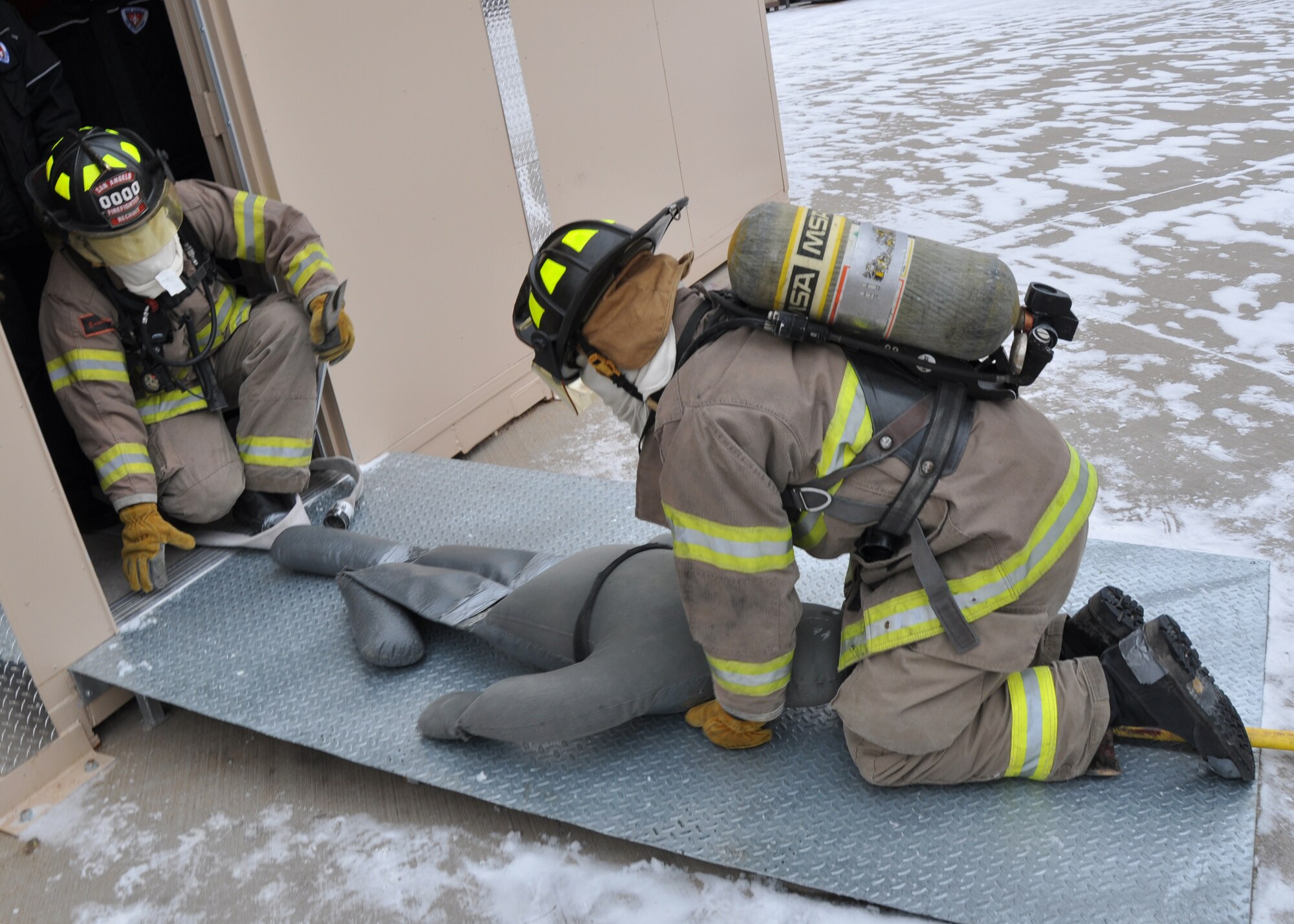 GOODFELLOW AIR FORCE BASE, Texas – Justin Nely and Steven Olsen, San Angelo Fire Department recruits, pull a dummy out of the search and rescue trainer at the Louis F. Garland DoD Fire Academy here Feb. 6. SAFD and Goodfellow used this trainer to test students’ ability to find people in a multi-room area while blindfolded. (U.S. Air Force photo/ Senior Airman Joshua Edwards)