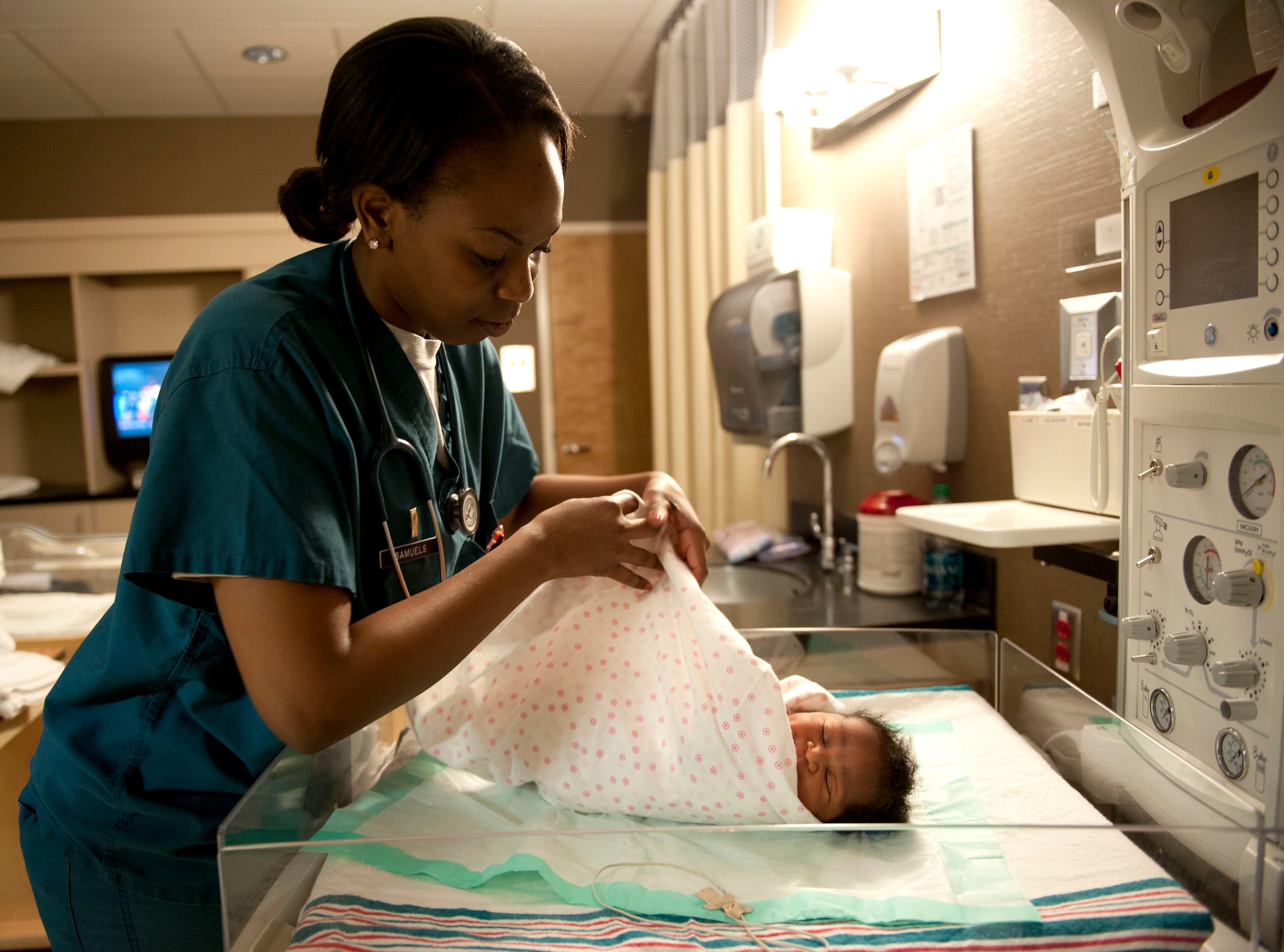 U.S. Air Force 2nd Lt. Quianna Samuels, 633rd Medical Group Labor and Deliver registered nurse, checks newborn Guinevere Grant, the daughter of Petty Officer 1st Class Xavier Grant, Patrol Coast Squadron electrician mate assigned to Joint Expeditionary Base Little Creek-Fort Story at Langley Air Force Base, Va., Jan. 30, 2014.  Samuels aided in the initial response to the West, Texas fertilizer plant explosion that put her nursing skills to the test.  (U.S. Air Force photo by 2nd Lt. Brooke Betit/Released)