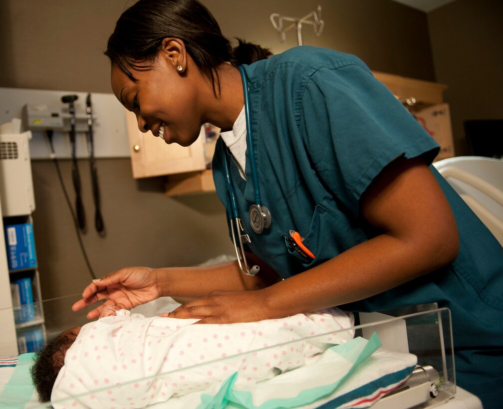 Newborn Guinevere Grant, the daughter of Petty Officer 1st Class Xavier Grant, Patrol Coast Squadron electrician mate assigned to Joint Expeditionary Base Little Creek-Fort Story grasps the finger of U.S. Air Force 2nd Lt. Quianna Samuels, 633rd Medical Group Labor and Deliver registered nurse, as Samuels assesses the newborn at Langley Air Force Base, Va., Jan. 30, 2014.  Samuels said the explosion in West, Texas impacted her and motivated her to do the best she can in her field. (U.S. Air Force photo by 2nd Lt. Brooke Betit/Released)