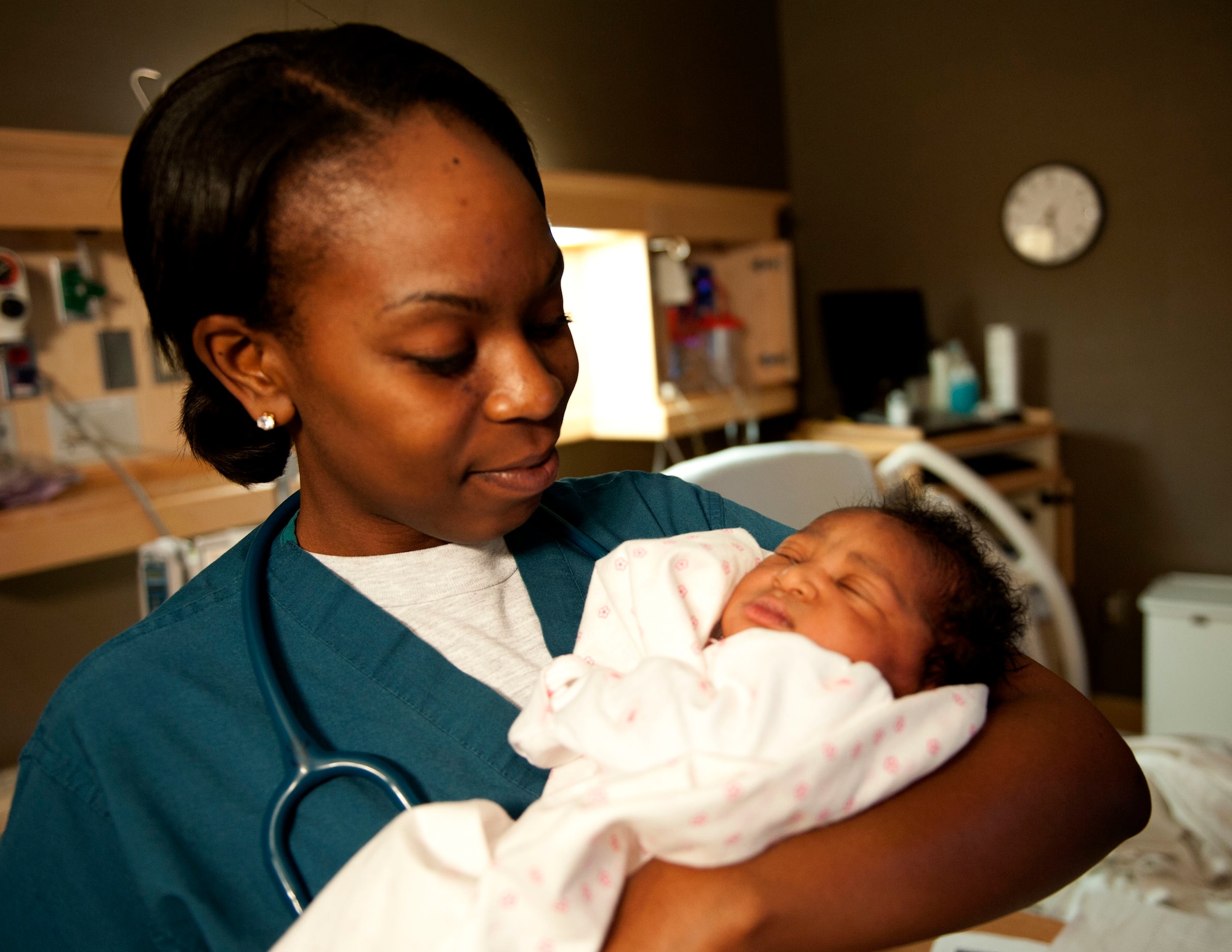 U.S. Air Force 2nd Lt. Quianna Samuels, 633rd Medical Group Labor and Deliver registered nurse, holds Guinevere Grant, the newborn daughter of Petty Officer 1st Class Xavier Grant, Patrol Coast Squadron electrician mate assigned to Joint Expeditionary Base Little Creek-Fort Story at Langley Air Force Base, Va., Jan. 30, 2014.  Samuels always had a passion to help people, as demonstrated on the evening of April 17, 2013, when she provided first-responder efforts to residents impacted by the fertilizer plant explosion in West, Texas. (U.S. Air Force photo by 2nd Lt. Brooke Betit/Released)