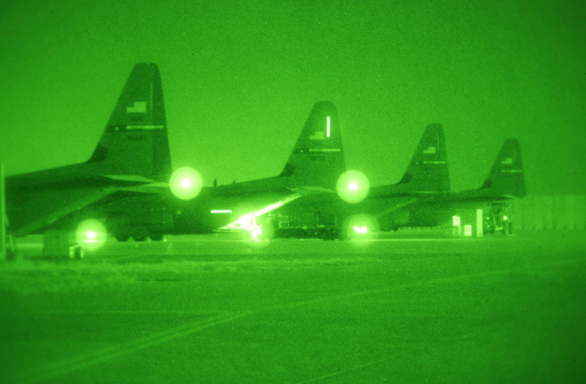 A row of four C-130J Super Hercules are parked at Bagram Airfield, Afghanistan, Feb. 11, 2014. Aerial port Airmen were loading one of the C-130J for a night mission. (U.S. Air Force photo by Capt. Brian Wagner/Released)