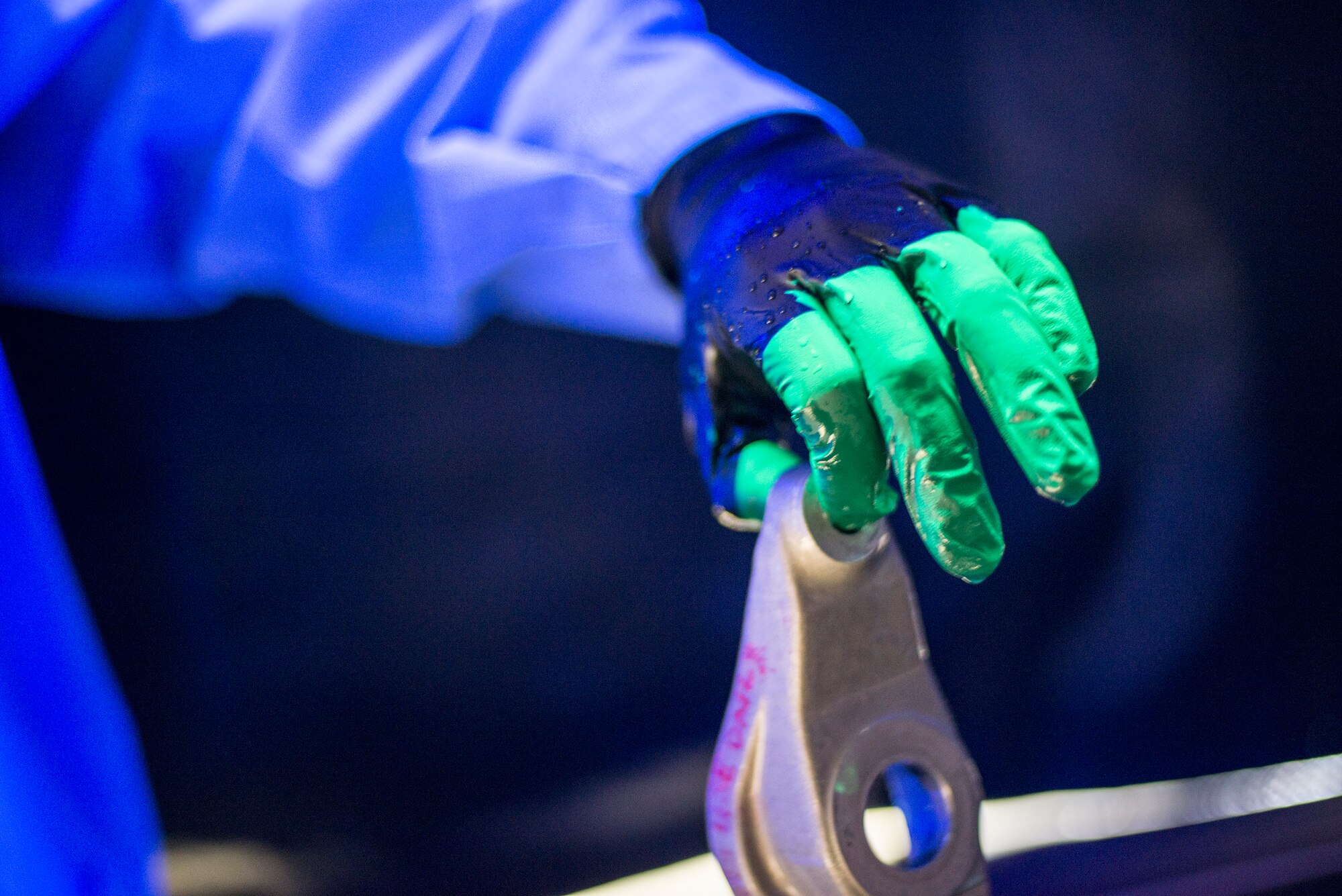 U.S. Air Force Airman Nicholas Burgess, 23d Equipment Maintenance Squadron non-destructive inspection apprentice, pulls a part from penetrant liquid at Moody Air Force Base, Ga., Feb. 11, 2014. After being submerged and dried, parts are inspected under blacklight for cracks and weak spots as a form of preventative maintenance. (U.S. Air Force photo by Airman 1st Class Ryan Callaghan/Released)
