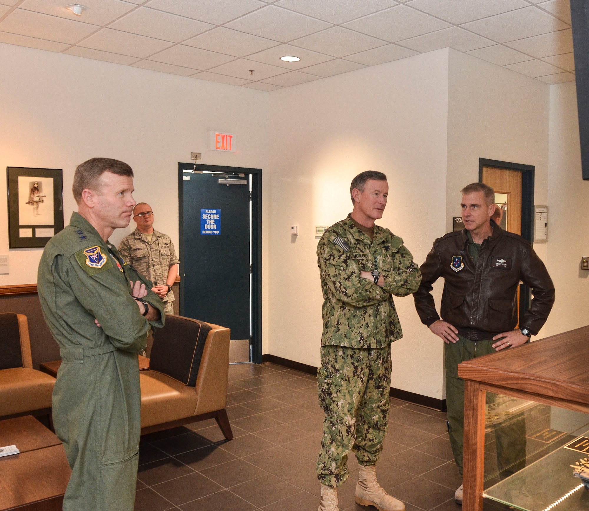 U.S. Navy Admiral William McRaven (center), Commander of U.S. Special Operations Command (USSOCOM), receives a briefing on the 612th Air and Space Operations Center from the Col. Bradley Pickens, 612th AOC deputy commander, during a visit to Davis-Monthan AFB, Ariz., Feb. 7, 2014. During his visit, visit, the admiral toured of the 612th AOC and spoke with AFSOUTH Airmen about their mission as the air component of U.S. Southern Command.   (U.S. Air Force photo by Staff Sgt. Adam Grant/Released) 