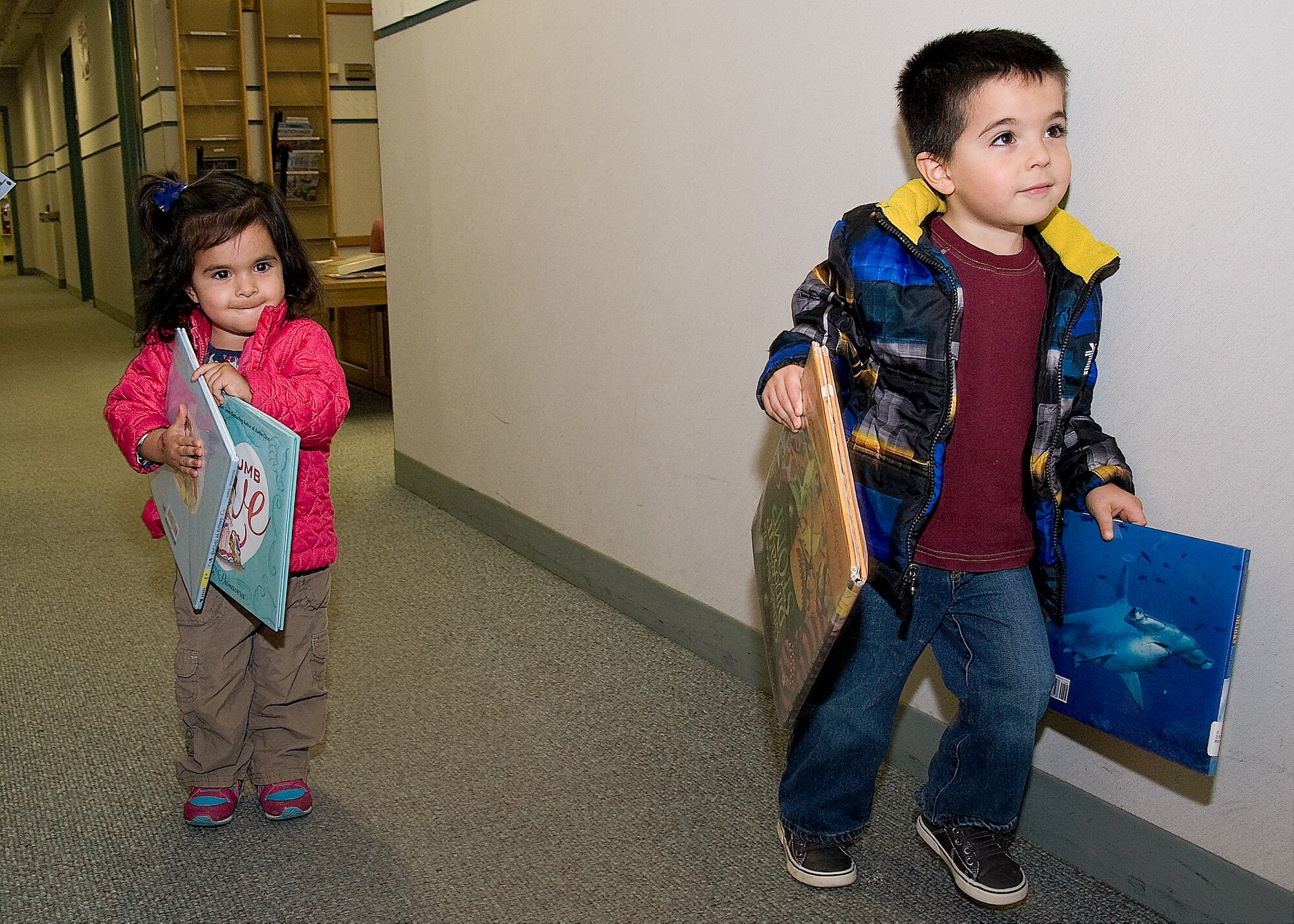 Olivia and Eli Garcia, children of 1st Lt. Juan Garcia, 436th Medical Operations Squadron family practice physician’s assistant, carry their books out of the base library Feb. 4, 2014, on Dover Air Force Base, Del. The children’s section will be moved to the Youth Center once the library transforms on March 21. (U.S. Air Force photo/Airman 1st Class Ashlin Federick)