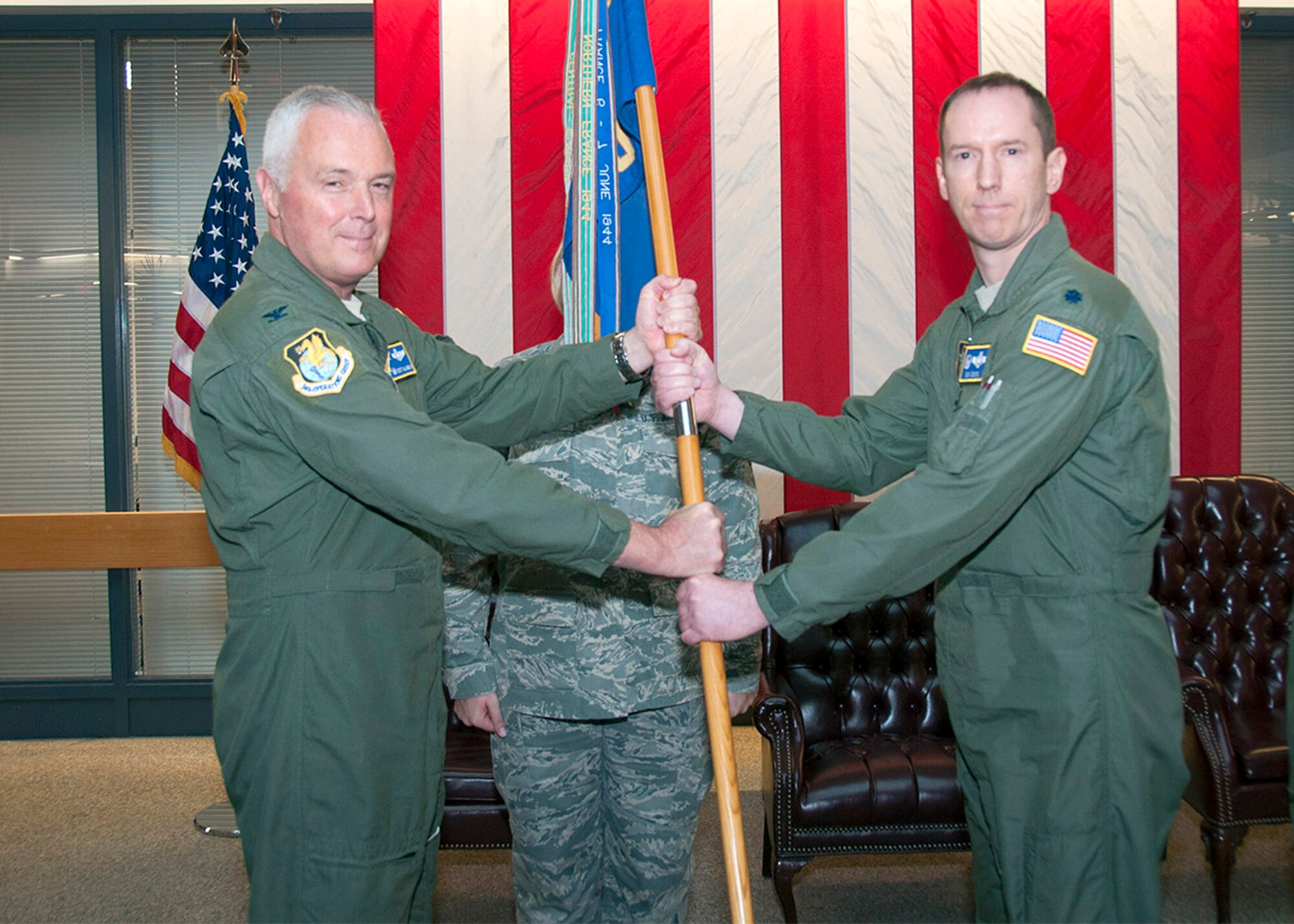 TRAVIS AIR FORCE BASE, Calif. -- Col. Scott McLaughlin, 349th Operations Group commander, transfers the 301st Airlift Squadron guidon to incoming squadron commander Lt. Col. Robert Osborn during a ceremony Feb. 8, 2014. (U.S. Air Force photo/Senior Master Sgt. Robert Wade) 