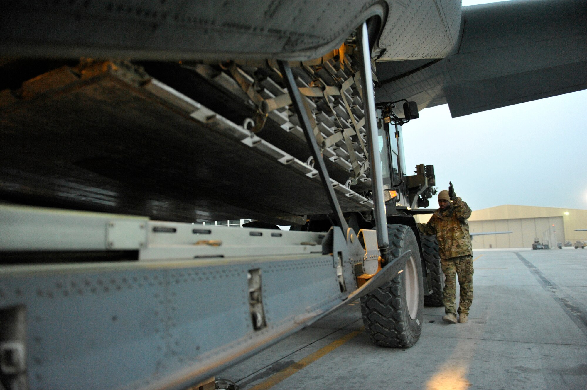 U.S. Air Force Senior Airman Solomon White directs a pallet into the back of a waiting C-130J at Bagram Airfield, Afghanistan, Feb. 10, 2014. White is a loadmaster deployed from Dyess Air Force Base and a native of Newport News, Va.(U.S. Air Force photo by Senior Master Sgt. Gary J. Rihn/Released)