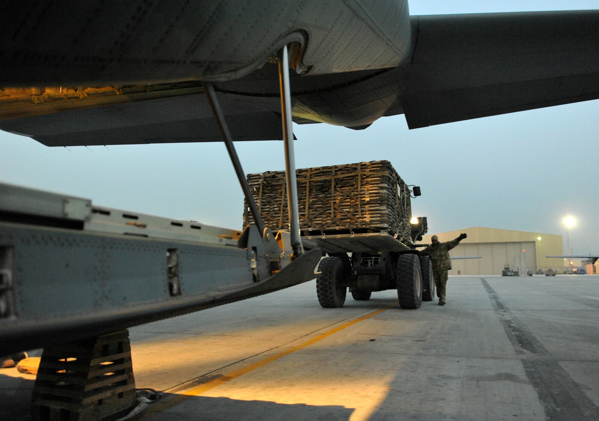 U.S. Air Force Senior Airman Solomon White directs a forklift to the back of a waiting C-130J at Bagram Airfield, Afghanistan, Feb. 10, 2014. White is a loadmaster deployed from Dyess Air Force Base and a native of Newport News, Va.(U.S. Air Force photo by Senior Master Sgt. Gary J. Rihn/Released)