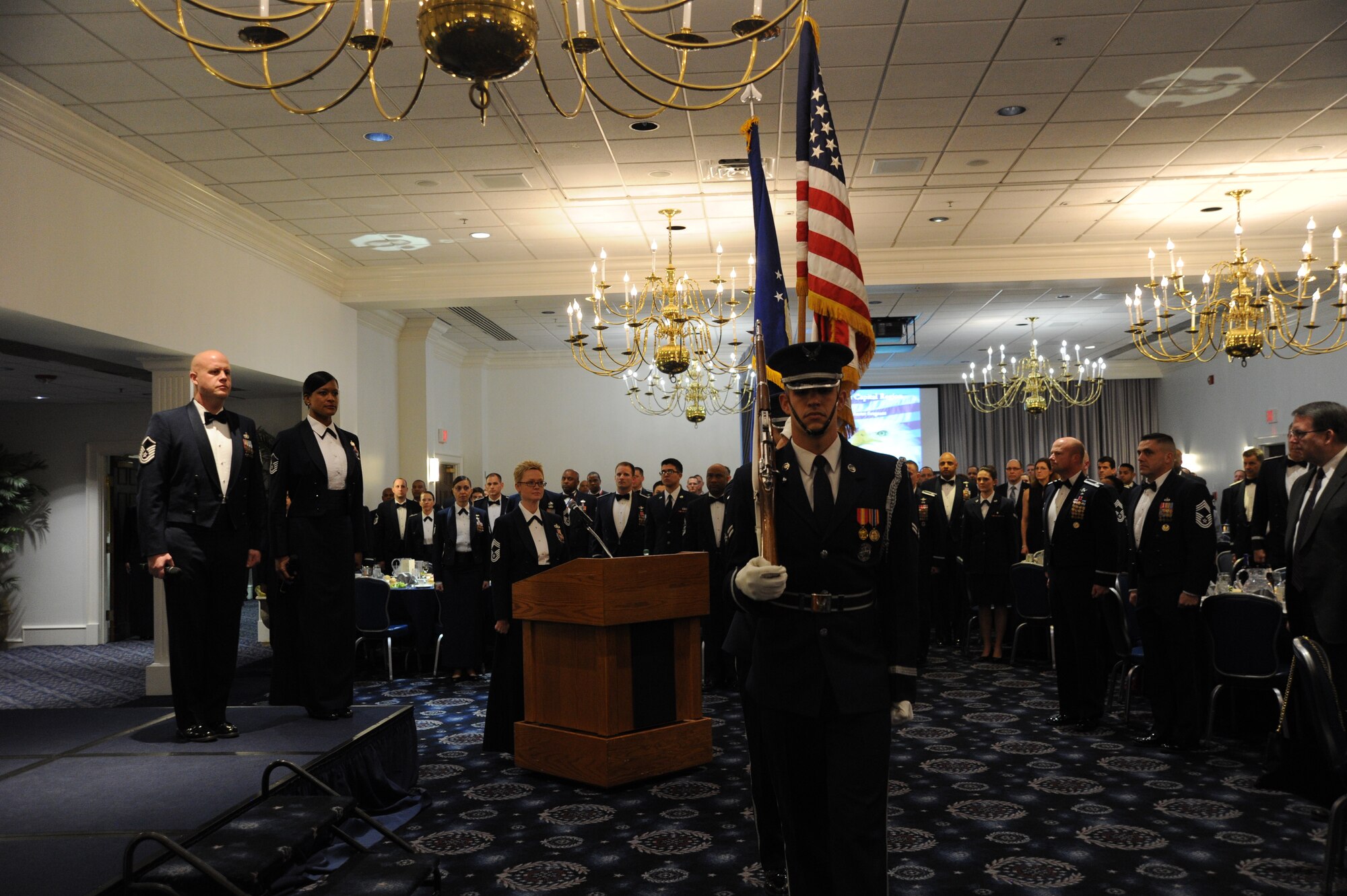 Members of the U.S. Air Force Honor Guard present the colors as Master Sgts. Ryan Carson (left) and Shani Prewitt stand ready to sing the National Anthem during the Chief Recognition banquet at Joint Base Anacostia-Bolling, D.C., Feb. 7, 2014. Carson and Prewitt are both vocalists for the U.S. Air Force Band rock group Max Impact. (U.S. Air Force photo/Master Sgt. Tammie Moore)