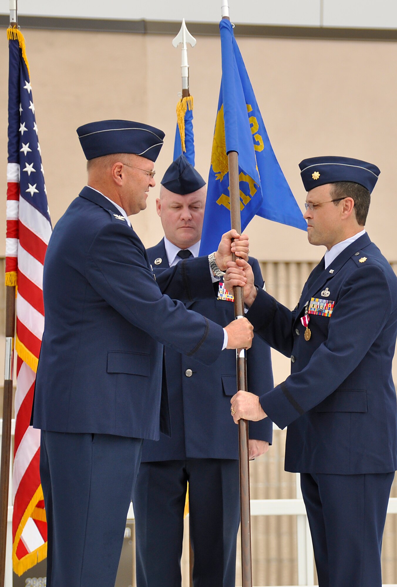 Col. Douglas Batson, 482nd Maintenance Group commander, Homestead Air Reserve Base, Fla., ceremoniously passes the squadron guidon to Maj. Jay Rodriguez, 482nd Maintenance Squadron commander, during the assumption of command ceremony, Feb. 9.