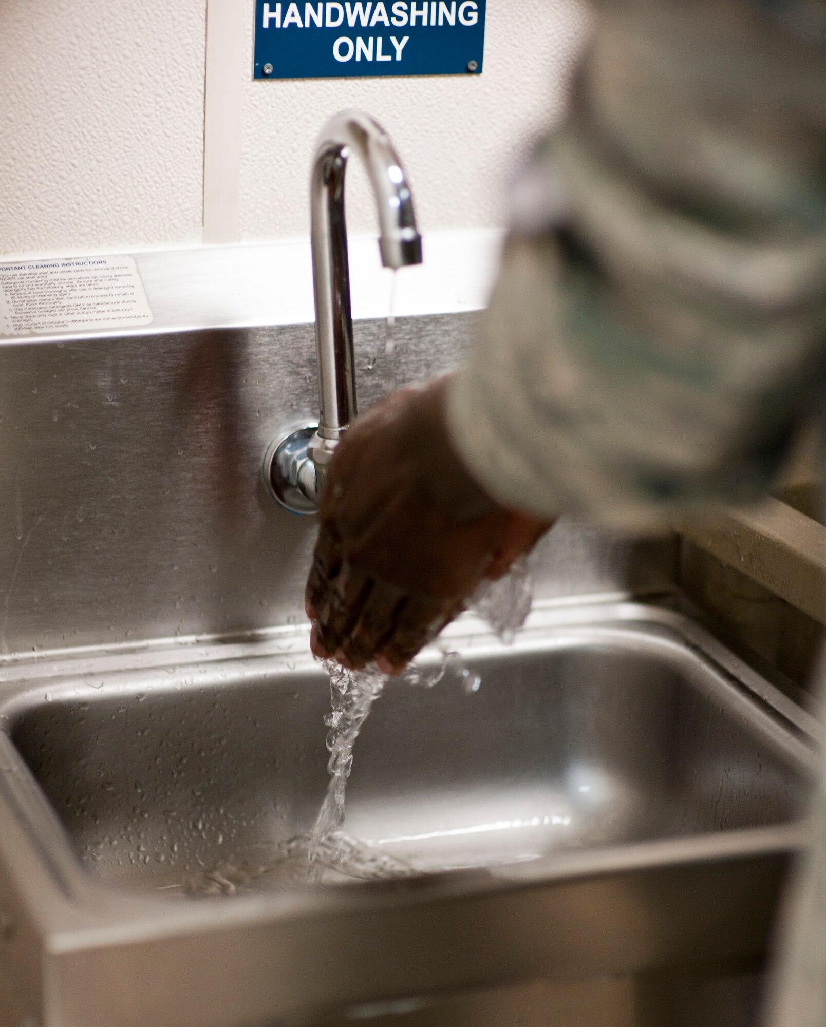 Airman 1st Class Cheikh Dieng, 1st Special Operations Force Support Squadron food service apprentice, washes his hands prior to preparing sandwiches at the Riptide Dining Facility on Hurlburt Field, Fla., Feb. 6, 2014. The flight kitchen operates 24/7 and provides pre-made supplement bags, which contain various food items. (U.S. Air Force photo/Senior Airman Krystal M. Garrett)