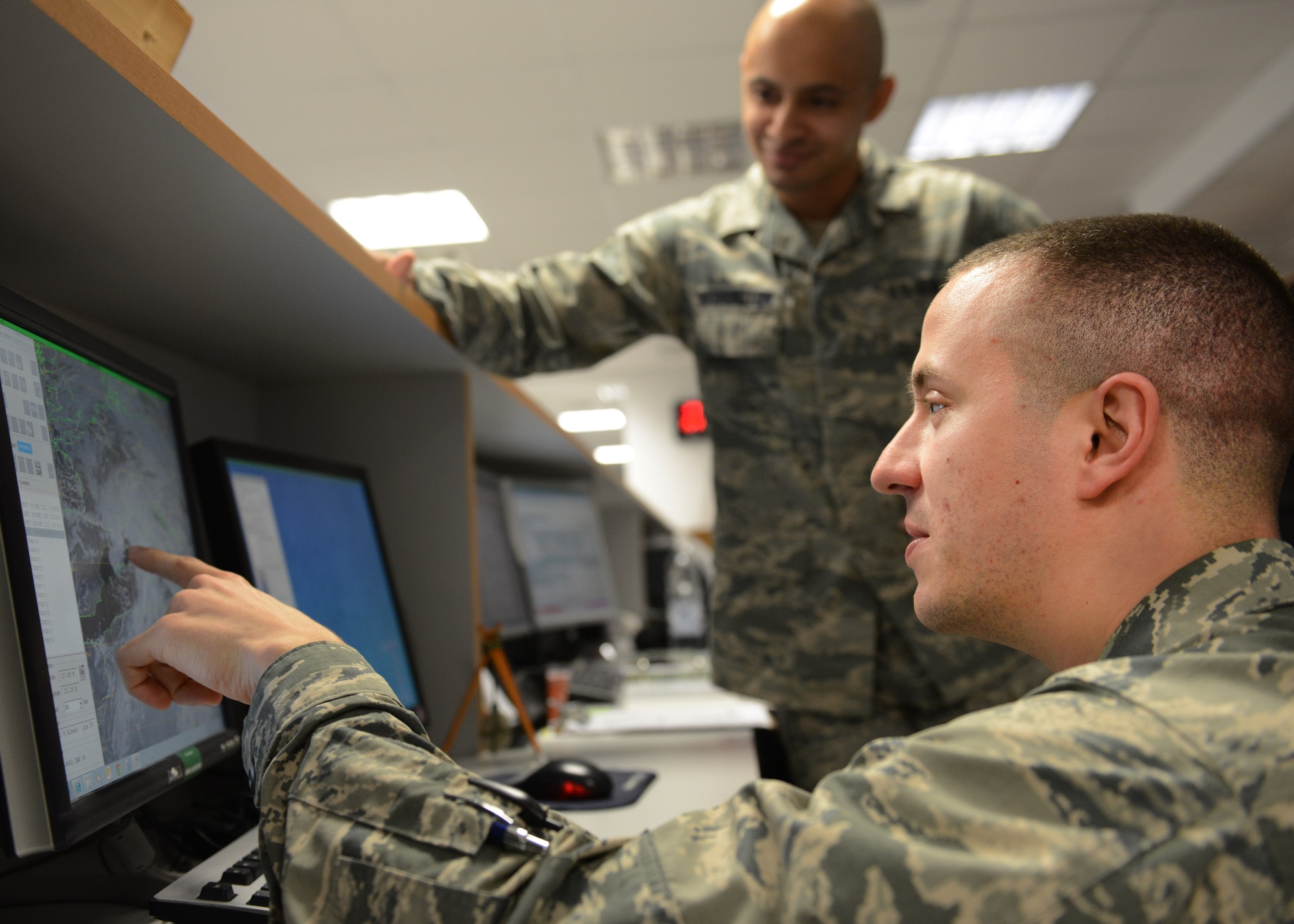 First Lieutenant David DeMeuse, 31st Operations Support Squadron Weather Flight commander points out a cloud pattern over Italian airspace to Staff Sgt. Charles Washington, 31st OSS weather flight member, Jan. 30, 2014, at Aviano Air Base, Italy. The weather flight employs the "eyes forward" approach using real-time radar, satellite imagery, sensor readouts and visual observations to tailor weather conditions specifically for the 31st Fighter Wing. (U.S. Air Force photo/Airman 1st Class Ryan Conroy) 