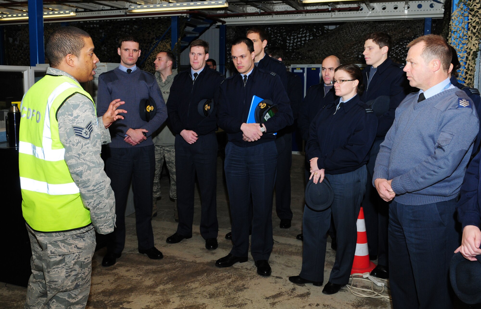 U.S. Air Force Staff Sgt. Colin Fitzpatrick, left, 100th Logistics Readiness Squadron NCO in charge of (the) small air terminal from Martinsville, Va., explains how the U.S. Air Force performs its cargo deployment function to RAF officers Feb. 5, 2014, at RAF Mildenhall, England. Student and instructor RAF officers from RAF Halton and RAF leadership from RAF High Wycombe, both in Buckinghamshire, spent the day touring 100th LRS facilities to familiarize themselves with how the U.S. Air Force does business. The visit with 100th LRS served to strengthen relationships and build partnerships between the two air forces and provided an insight into the similarities and differences in how both work. (U.S. Air Force photo by Karen Abeyasekere/Released)