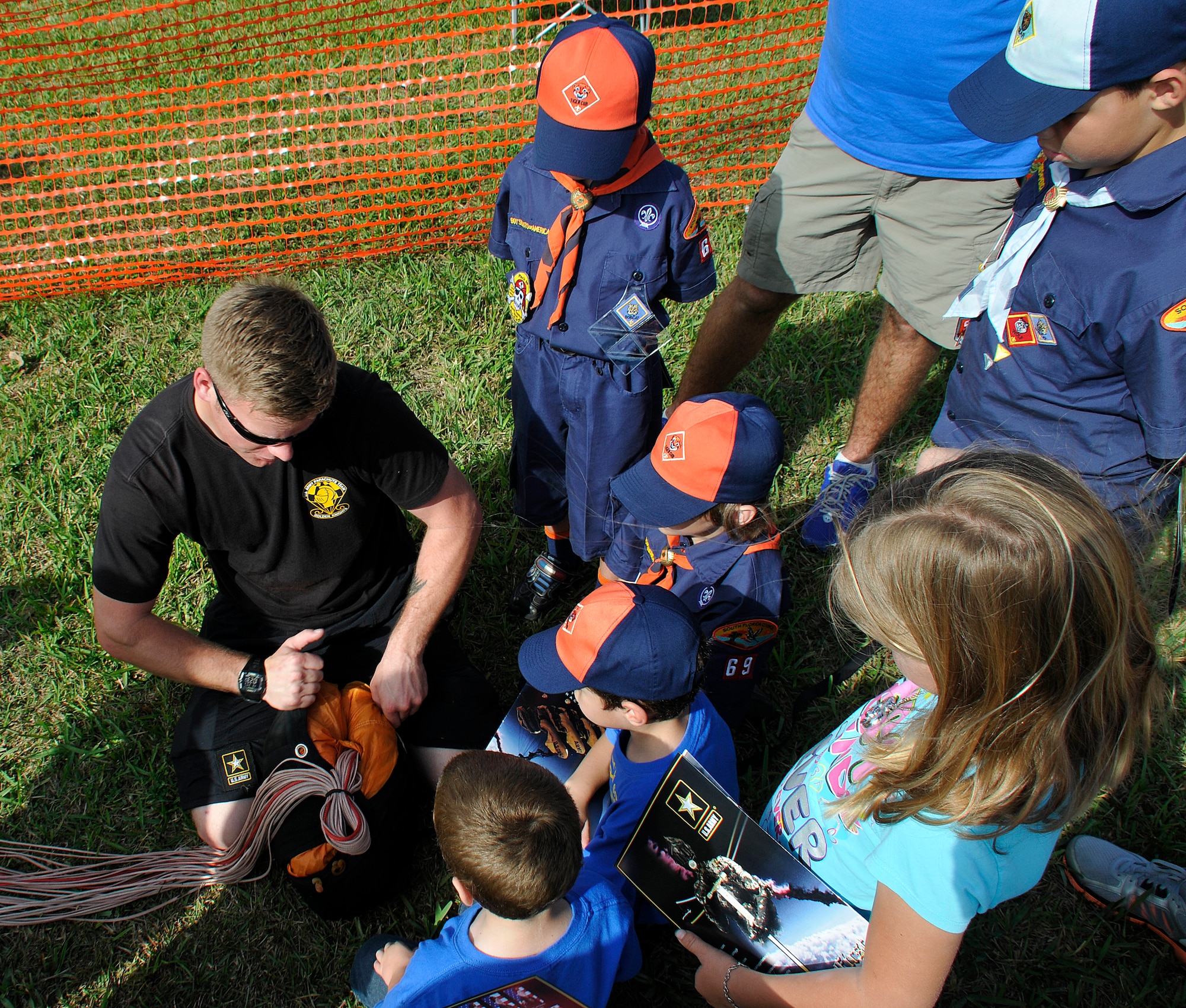 SGT. David Flynn, a member of the U.S. Army parachute team: The Golden Knights, shows a group of Tiger Cub Scouts from Pack 69, Homestead Fla., how to pack a parachute during a tour of Homestead Air Reserve Base, Fla., on Jan. 29. The Golden Knights are at Homestead ARB conducting their winter training. (U.S. Air Force photo/Tim Norton)