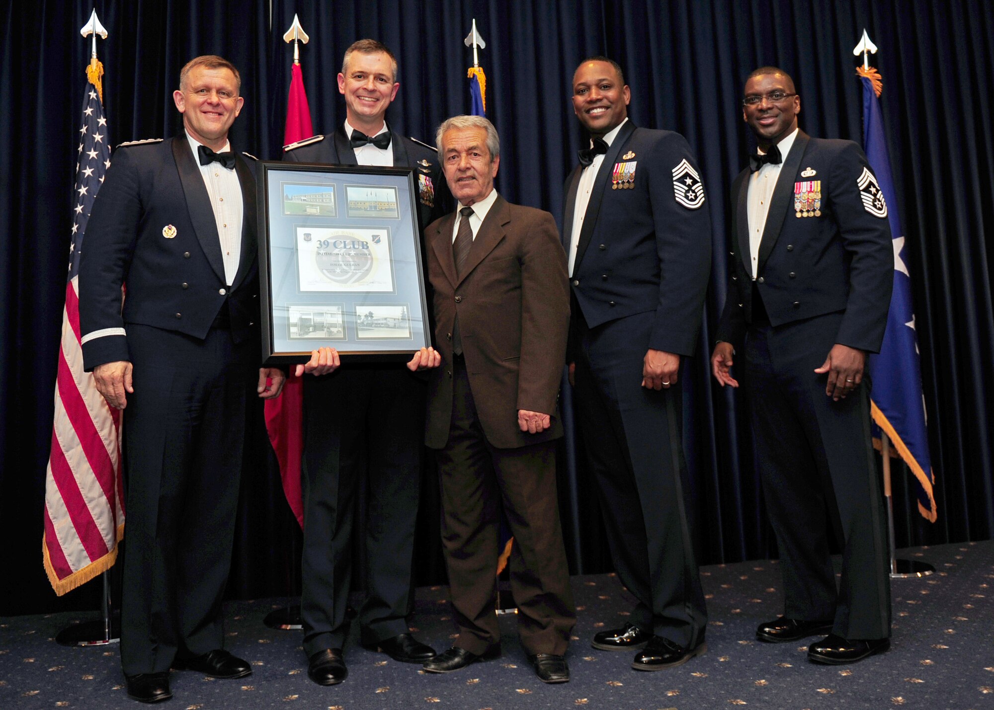 Ismail Gulhan, 39th Security Forces Squadron, is welcomed into the 39 Club by U.S. Air Forces in Europe and 39th Air Base Wing senior leadership at the Combined Club Complex Feb. 4, 2014. The memento presented to members of the 39 Club contains photos of Incirlik Air Base past and present along with a certificate of appreciation for their long-term service. (U.S. Air Force photo by Airman 1st Class Nicole Sikorski/Released)