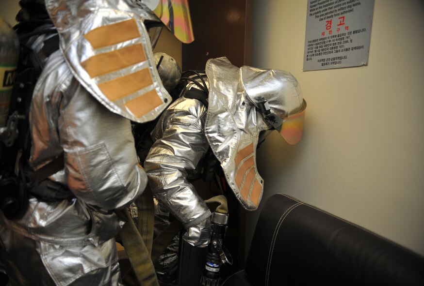 Firefighters from the 51st Civil Engineer Squadron Fire Department search for simulated victims inside Bldg. 949 as part of a mock structure fire and bug-out scenario during Operational Readiness Exercise Beverly Midnight 14-02 at Osan Air Base, Republic of Korea, Feb. 11, 2014. The firefighters successfully extinguished the mock fires, simulated by small flashing lights, and rescued a casualty role player during their primary search of the building and then completed a secondary search to ensure there were no additional victims or fires inside other rooms. (U.S. Air Force photo/Airman 1st Class Ashley J. Thum)