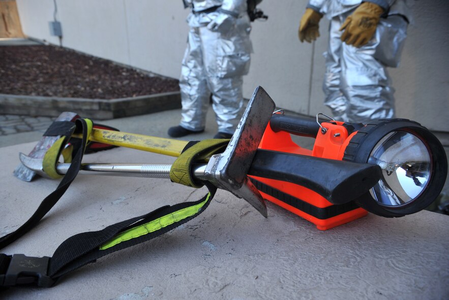 A Halligan entry tool, fire axe and industrial flashlight are staged near the entrance of Bldg. 949 during a mock structure fire and bug-out scenario as part of Operational Readiness Exercise Beverly Midnight 14-02 at Osan Air Base, Republic of Korea, Feb. 11, 2014. Firefighters keep implements like these close at hand when preparing to enter a building on fire in the event they must break through a door or need a source of light to see through smoke. (U.S. Air Force photo/Airman 1st Class Ashley J. Thum) 