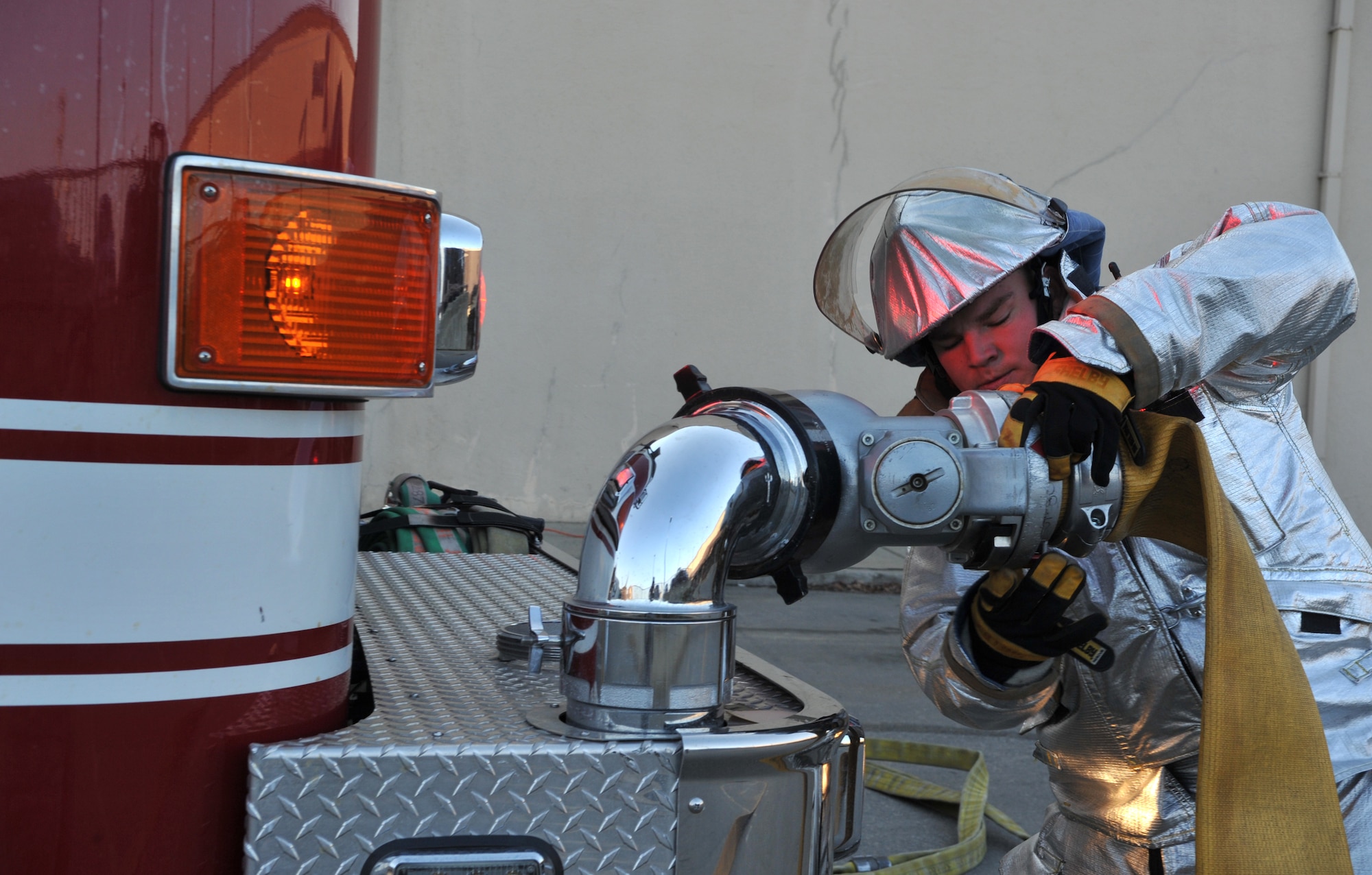 A firefighter from the 51st Civil Engineer Squadron Fire Department secures a fire hose to a fire engine outside Bldg. 949 as part of a mock structure fire and bug-out scenario during Operational Readiness Exercise Beverly Midnight 14-02 at Osan Air Base, Republic of Korea, Feb. 11, 2014. OREs test the ability of firefighters and other emergency responders to quickly mobilize and respond to potentially dangerous situations. (U.S. Air Force photo/Airman 1st Class Ashley J. Thum)