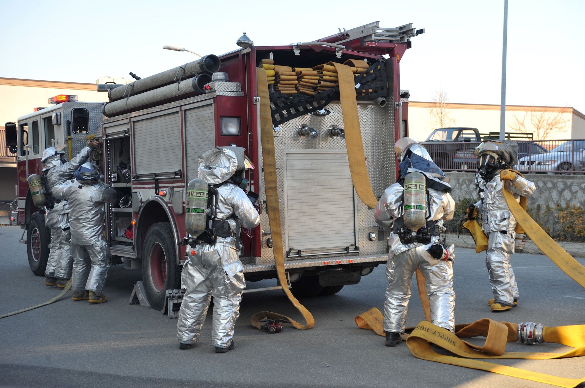 Firefighters from the 51st Civil Engineer Squadron Fire Department unravel fire hoses and unpack other firefighting equipment outside Bldg. 949 as part of a mock structure fire and bug-out scenario during Operational Readiness Exercise Beverly Midnight 14-02 at Osan Air Base, Republic of Korea, Feb. 11, 2014. The situation tested the group’s ability to reach the required firefighting benchmarks, including stopping the simulated fire and performing primary and secondary searches for mock victims. (U.S. Air Force photo/Airman 1st Class Ashley J. Thum)