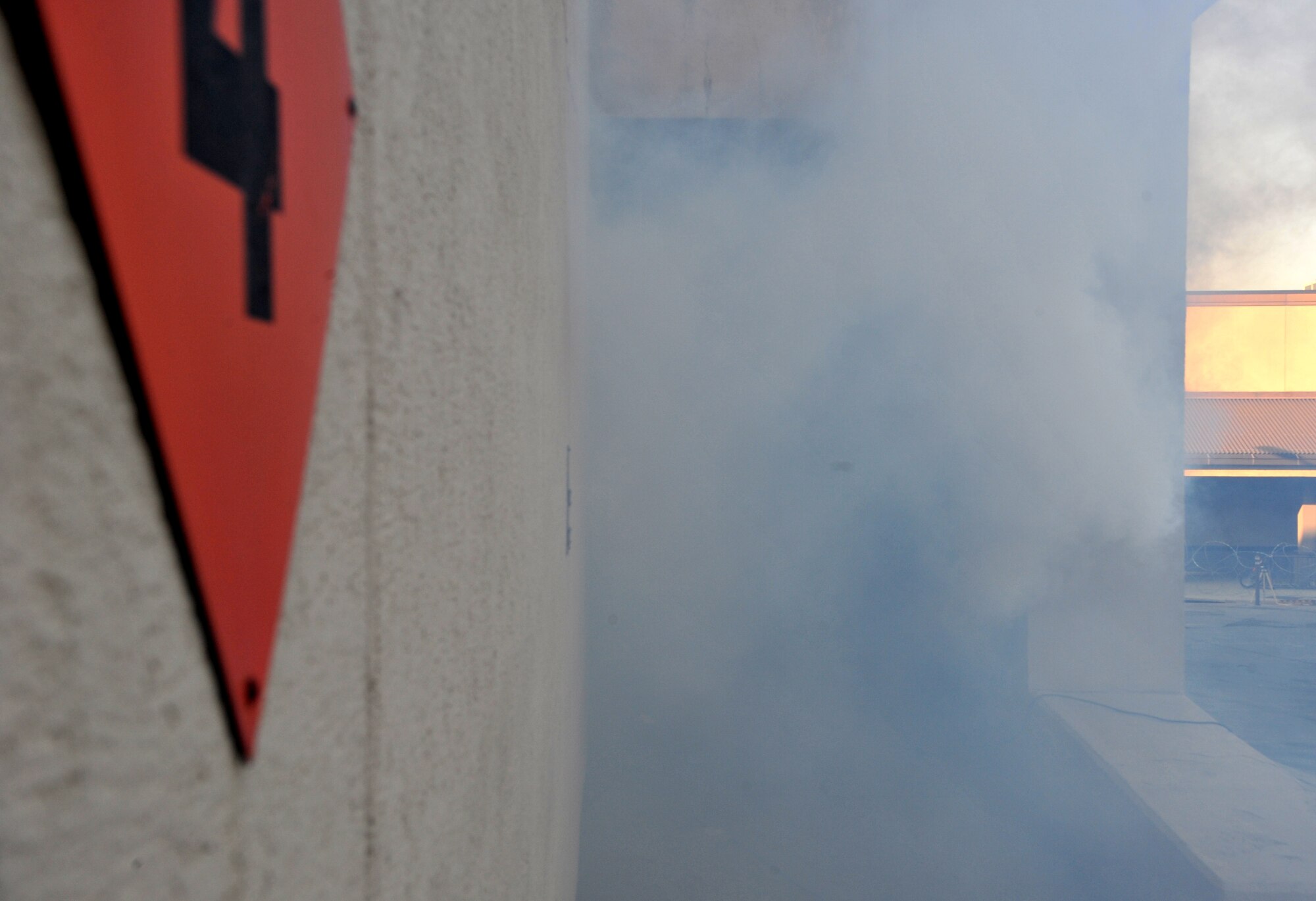 Smoke emanates from a smoke machine placed near Bldg. 949 as part of a mock structure fire and bug-out scenario during Operational Readiness Exercise Beverly Midnight 14-02 at Osan Air Base, Republic of Korea, Feb. 11, 2014. The squadron was required to make its way out of the structure and rally at a designated location, giving emergency responders the ability to stabilize the situation. (U.S. Air Force photo/Airman 1st Class Ashley J. Thum)