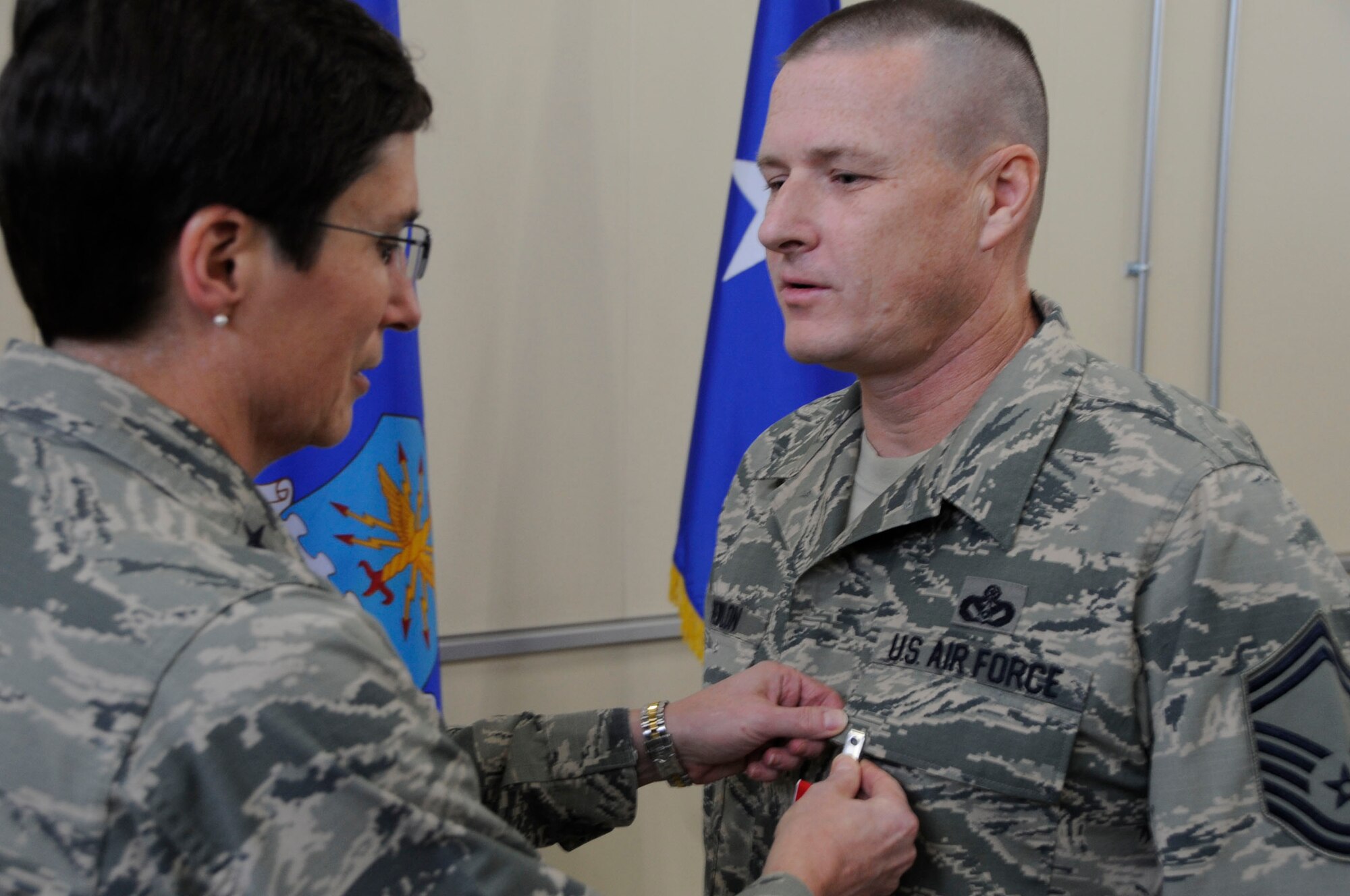 Maj. Gen. Theresa C. Carter, Deputy Chief of Staff for Logistics, Installations and Mission Support, Air Force Headquarters,  pins a Bronze Star Medal onto Senior Master Sgt. Matthew L. Newlon, 35th Civil Engineering Squadron infrastructure superintendent during an all call ceremony for the 35 CES at Misawa Air Base, Japan, Feb. 2, 2014. Newlon received the Bronze Star for  his service during a recent deployment to Bagram Air Base, Afghanistan, in support of Operation NEW DAWN. (U.S. Air Force photo/Airman 1st Class Patrick S. Ciccarone)