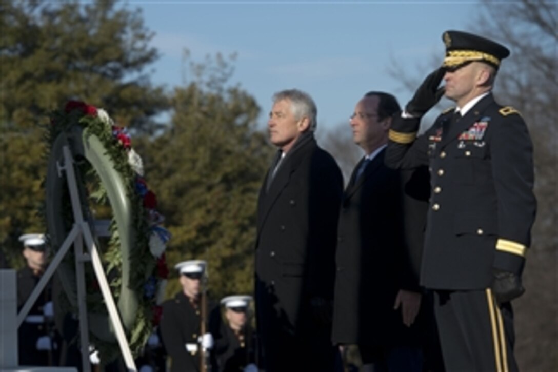 U.S. Defense Secretary Chuck Hagel, left, and French President Francois Hollande stand in front of a wreath at the Tomb of the Unknowns at Arlington National Cemetery in Arlington, Va., Feb. 11, 2014. Hagel thanked Hollande for laying the wreath and for presenting the World War II Unknown with the French Legion of Honor, France's highest military award.