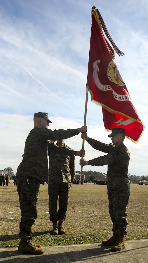 Lieutenant Col. Charles R. Cassidy passes the battalion’s colors to Col. Tim Powers at William Pendleton Thompson Hill Field Feb. 6, 2014, signifying the changing of command and the passing of responsibilities. “You have set the bar high, but we will try our best to meet the standard you have set,” said Powers while addressing the Marines, as the new Commanding Officer.