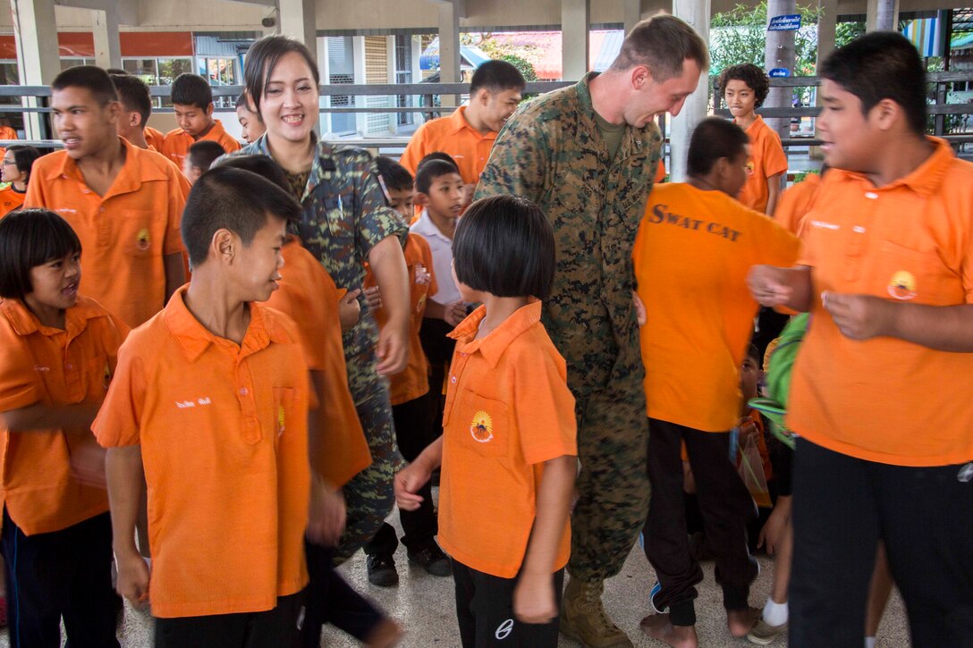 Flight Lt. Jirayu Doungnui, left, and Cpl. Michael Pigg dance with students from Nakhon Ratchasima Punyanukul School in Nakhon Ratchasima, Kingdom of Thailand, during a community relations event for exercise Cobra Gold 2014 Feb. 11. CG 14 is a joint, multinational exercise conducted annually in the Kingdom of Thailand aimed at enhancing and increasing multinational` interoperability. Doungnui is with Civil Affairs, Royal Thai Air Force. Pigg is a chemical, biological, radiological, and nuclear defense specialist with Marine Aircraft Group 12, 1st Marine Aircraft Wing, III Marine Expeditionary Force. (U.S. Marine Corps photo by Cpl. James R. Smith/released)