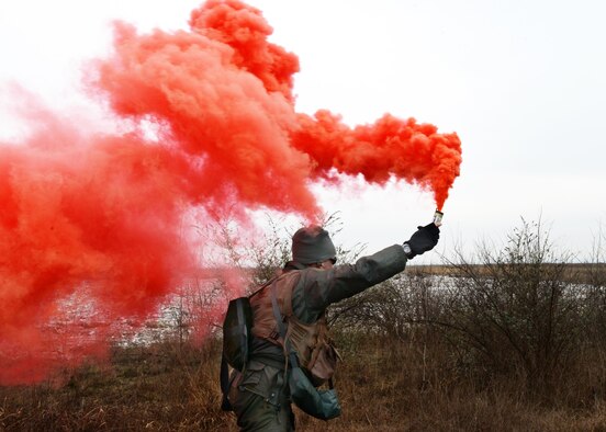 Lt. Col. Christopher Austin, 510th Fighter Squadron commander, utilizes red distress smoke to signal his location to a U.S. Army 12th Combat Aviation Brigade UH-60 Black Hawk helicopter during a simulated combat search and rescue, Jan. 28, 2014, at Cellina Meduna training grounds near Maniago, Italy.  (U.S. Air Force/Airman 1st Ryan Conroy) 
