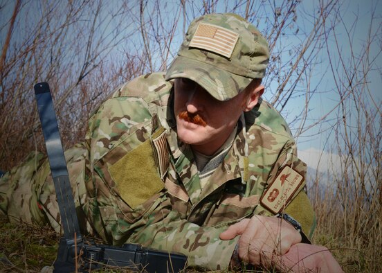 Staff Sgt. Claude Brown, 31st Operations Support Squadron survival, evasion, recovery and escape specialist, waits for a radio response from 31st Fighter Wing pilots during a simulated combat search and rescue mission, Jan. 28, 2014, at Cellina Meduna training ground near Maniago, Italy. (U.S. Air Force photo/Airman 1st Class Ryan Conroy) 
